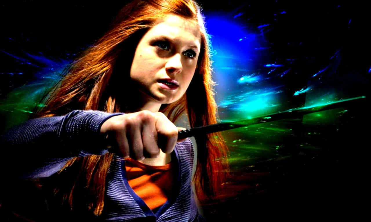 Ginny Weasley 桌布 壁紙 — 一位紅髮年輕女子在黑暗的宇宙背景下揮舞著發光的綠色魔杖，背景中有電光藍色和綠色的條紋。