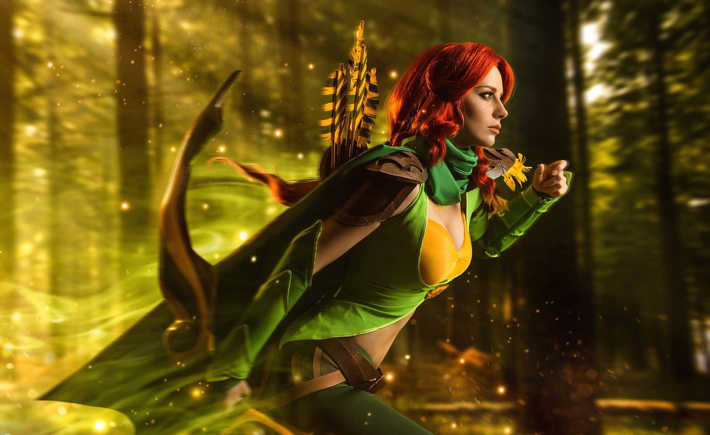 Windranger 桌布 壁紙 — 一位紅髮弓箭手身穿綠色和黃色盔甲，在陽光明媚的森林中擺好姿勢，箭矢在她背上顫動，金色光芒在她周圍閃爍。