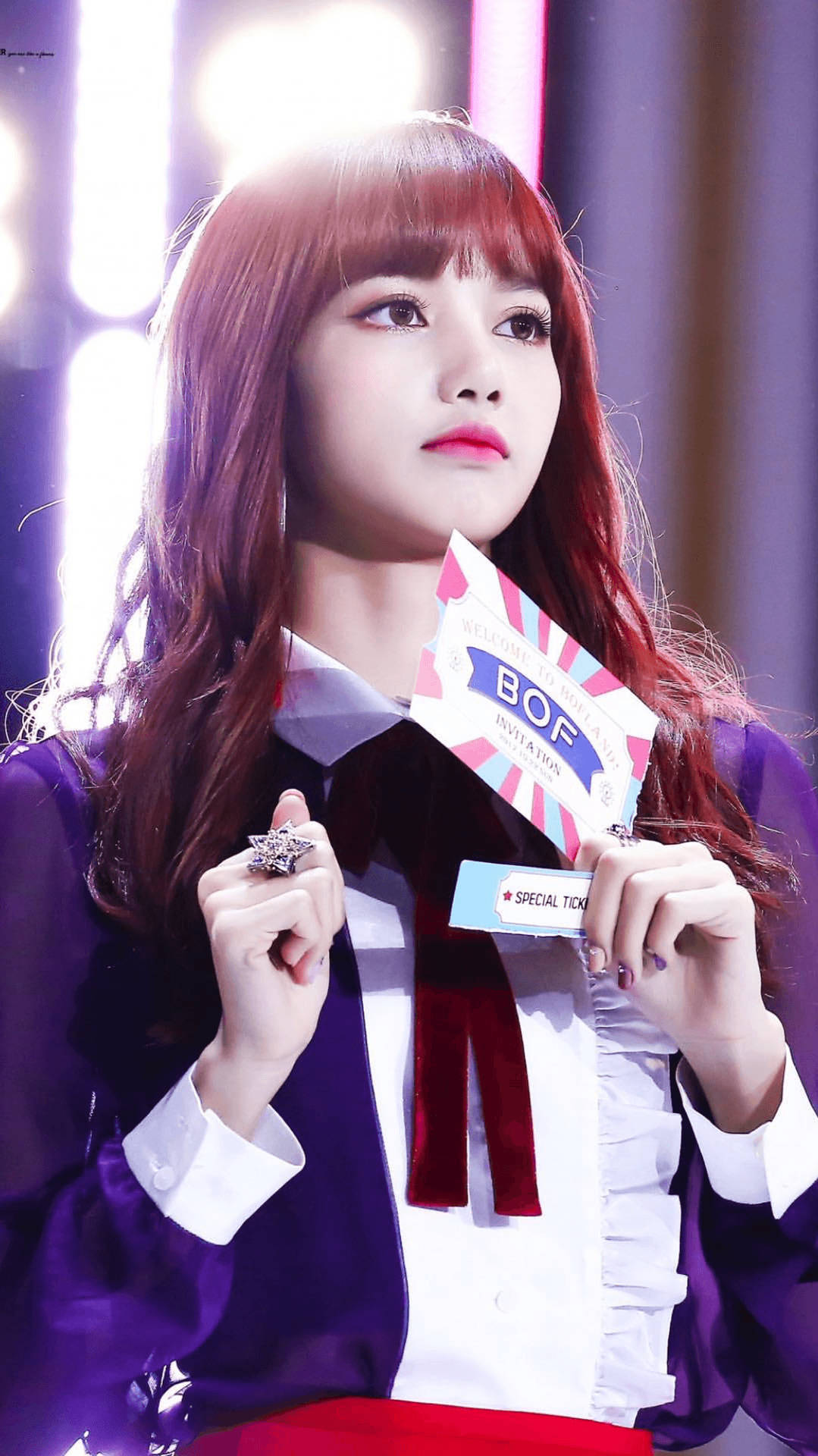 lisa 桌布 壁紙 — 一位紅髮紫衣的年輕女子在明亮的舞台燈光下手持BOF門票。