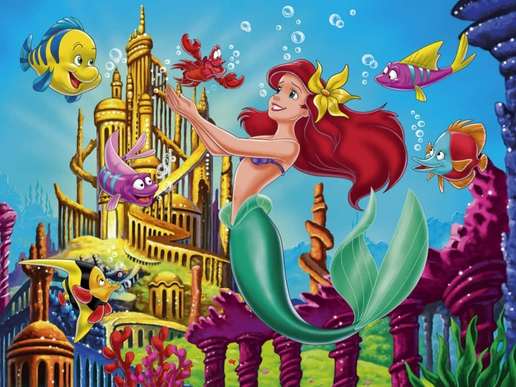愛麗兒 桌布 壁紙 — 一位紅髮綠尾的美人魚在水下微笑，周圍環繞著色彩繽紛的魚類和一座金色城堡。