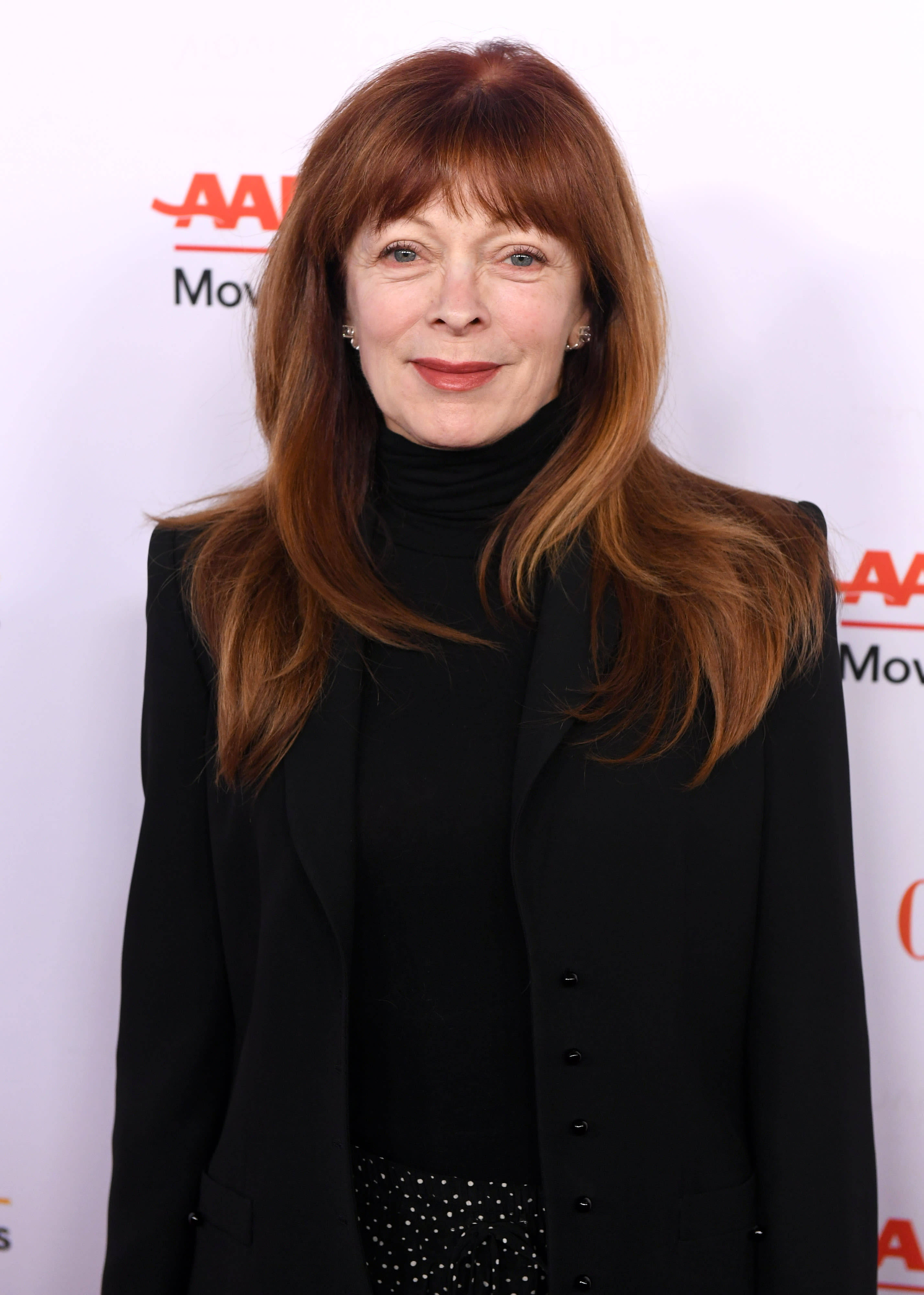 Celebrity 桌布 壁紙 — 一位紅髮黑衣女子在白色活動背景前對著鏡頭微笑。