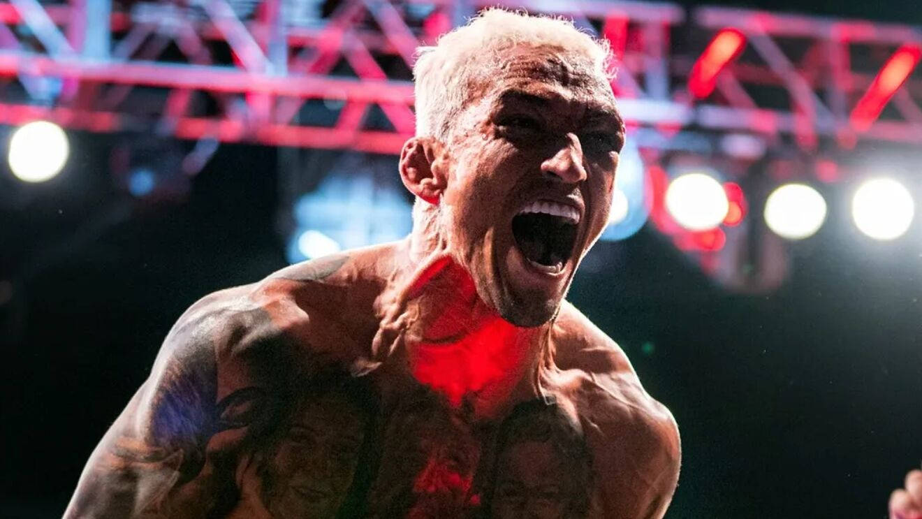 MMA 桌布 壁紙 — 一位紋身、漂染頭髮的摔角手在明亮的舞台燈光下，於摔角擂台上發出勝利的咆哮。