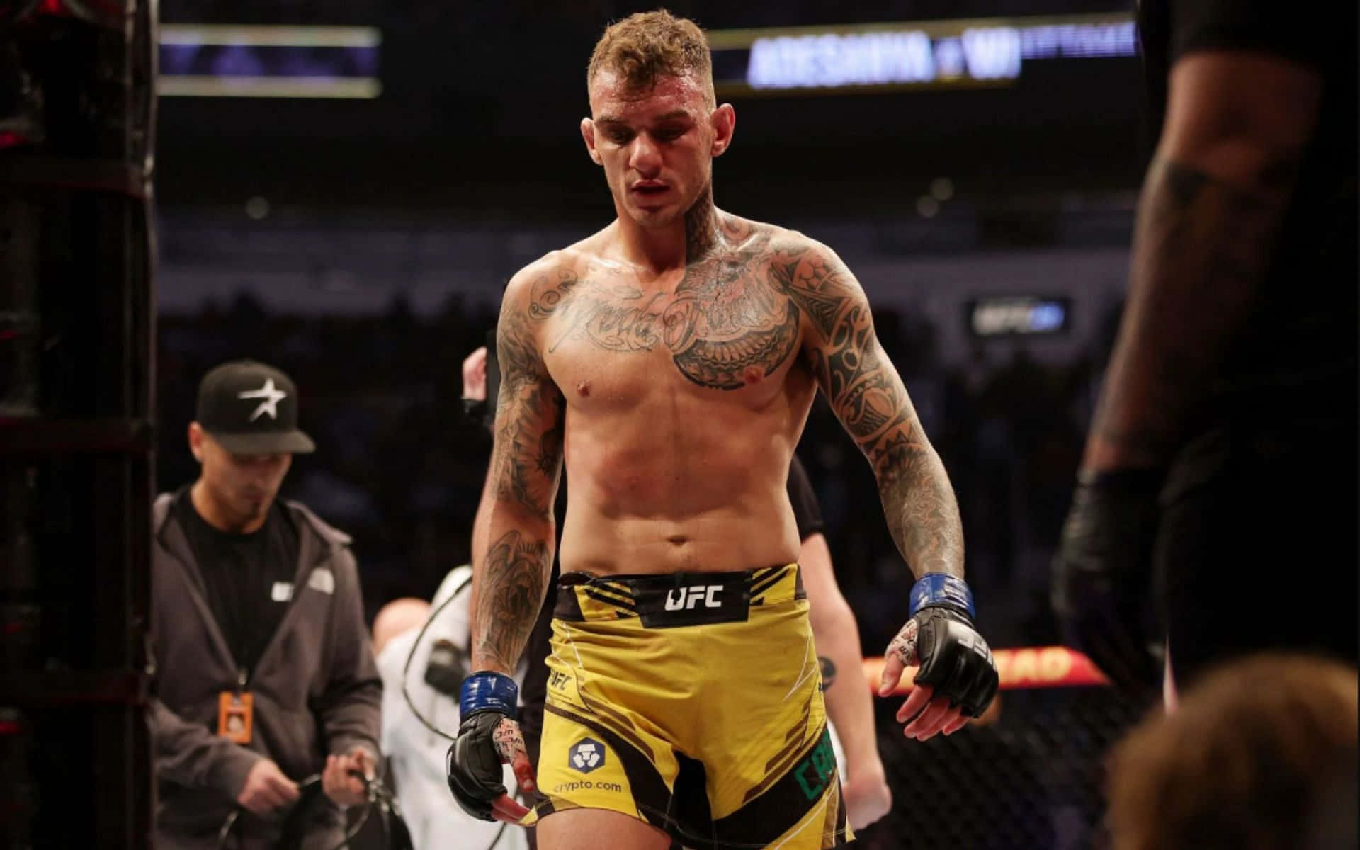 運動 桌布 壁紙 — 一位紋身的MMA拳手穿著黃色UFC短褲，在場館燈光下走出八角籠。
