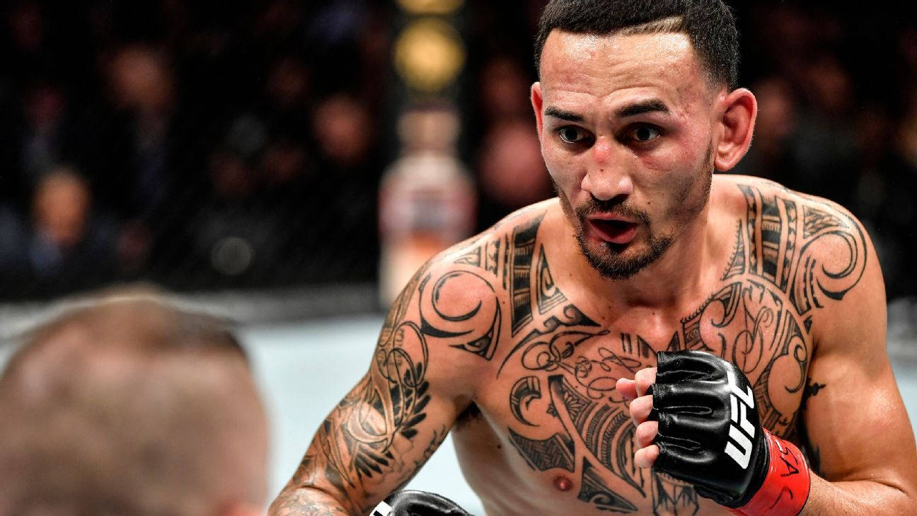 UFC 桌布 壁紙 — 一位紋身的混合武術選手戴著黑色手套，在明亮的場館燈光下於UFC比賽中專注地凝視。
