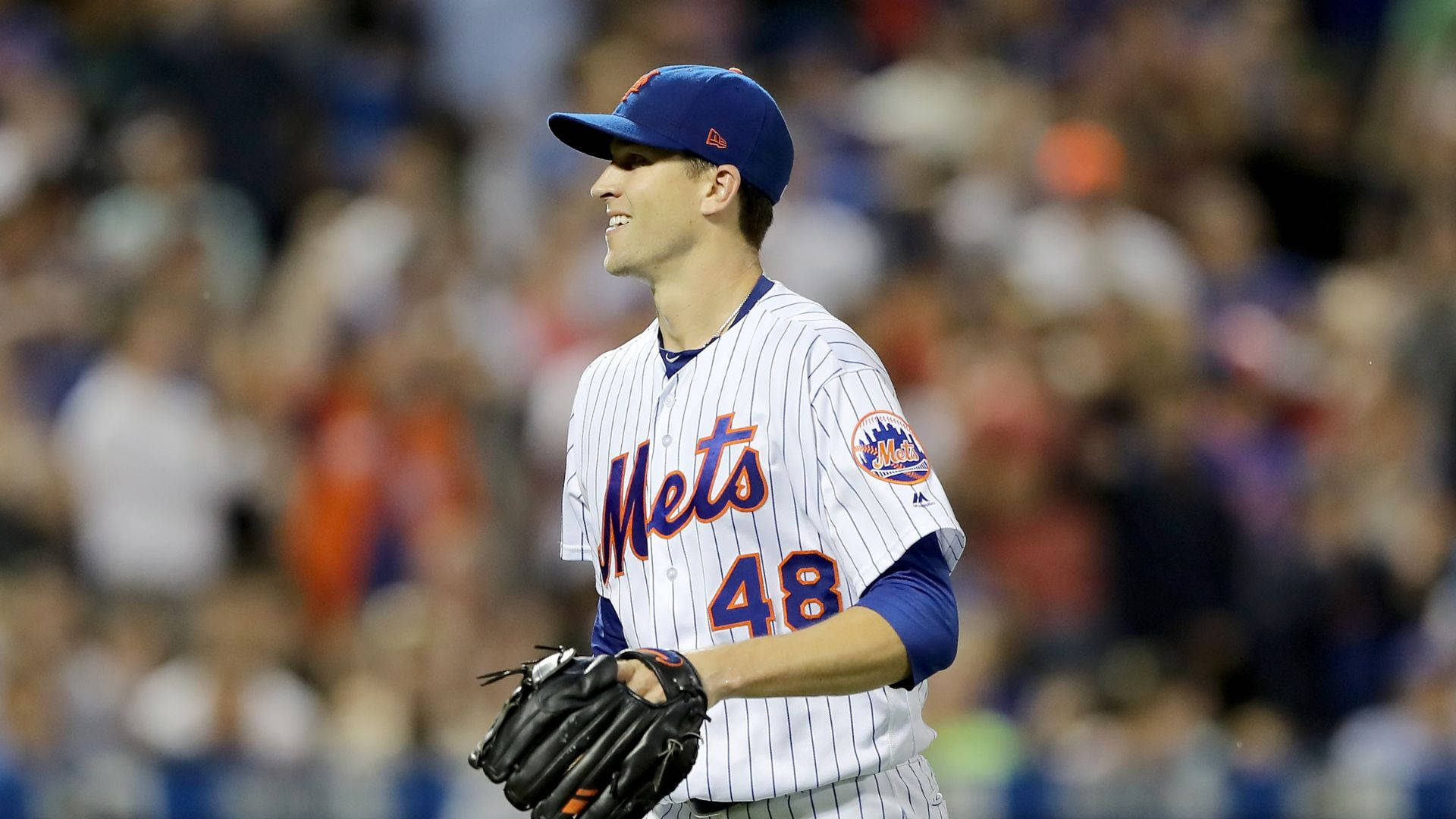 Degrom 桌布 壁紙 — 一位紐約大都會棒球選手穿著細條紋制服，在夜間比賽中於球場燈光下微笑著拿著手套。