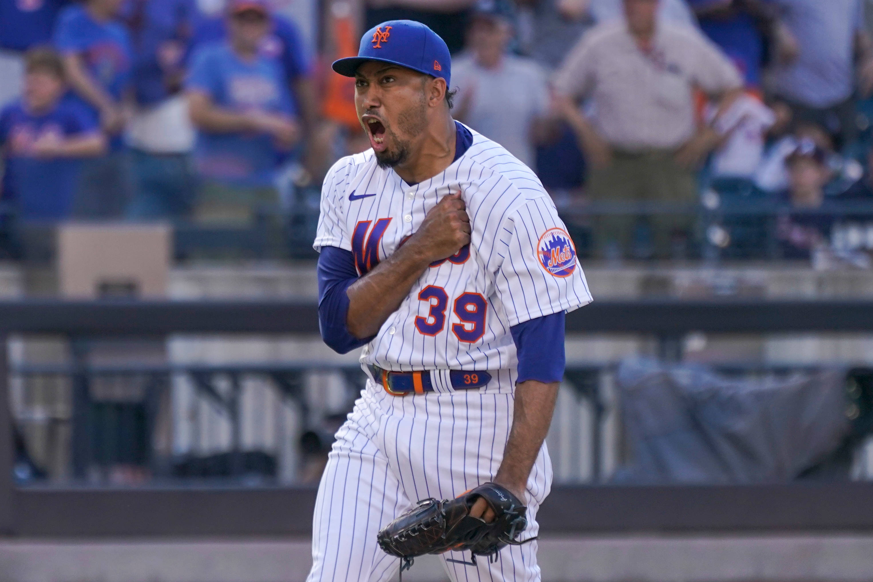 MLB Players 桌布 壁紙 — 一位紐約大都會棒球選手身穿細條紋制服背號39號，在陽光明媚的球場上握拳發出勝利的怒吼。