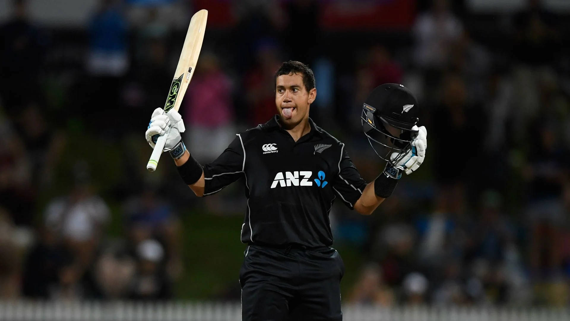 Ross Taylor 桌布 壁紙 — 一位紐西蘭板球運動員在夜間球場上伸出舌頭，用球棒和頭盔慶祝。