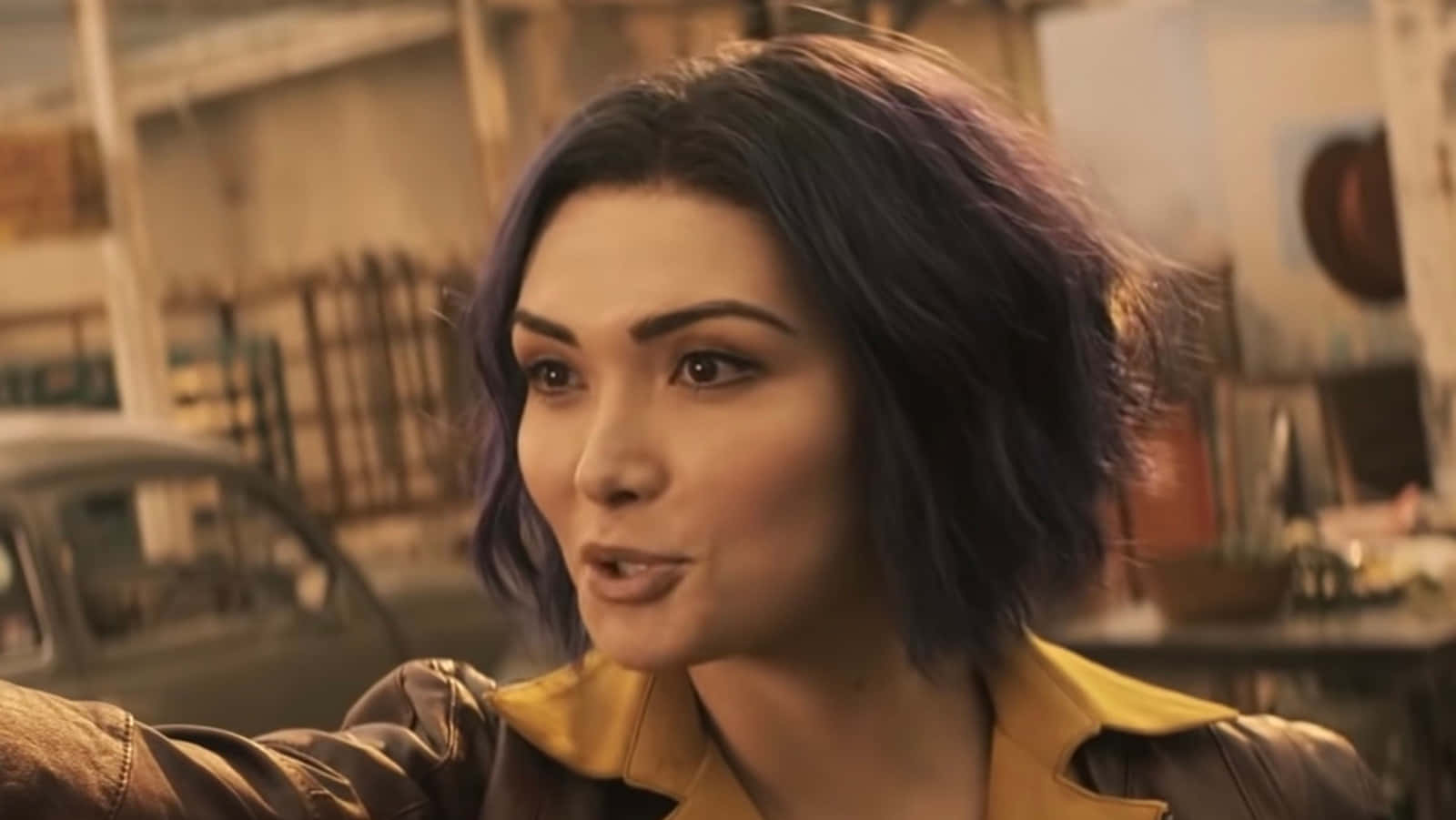 Faye Valentine 桌布 壁紙 — 一位紫髮女子身穿皮夾克，在粗獷的城市環境中專注地向前凝視。