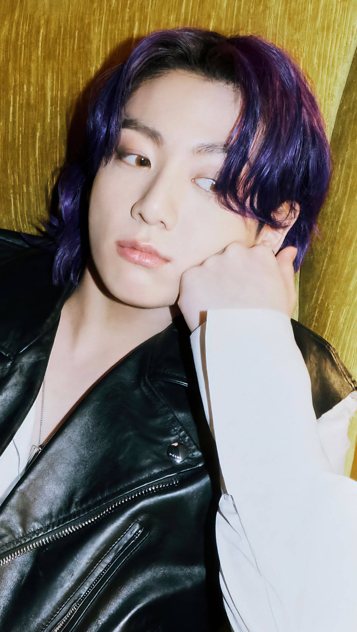 Jungkook 桌布 壁紙 — 一位紫髮年輕人，在紋理金色背景上，用手托著下巴，身穿黑色皮夾克。
