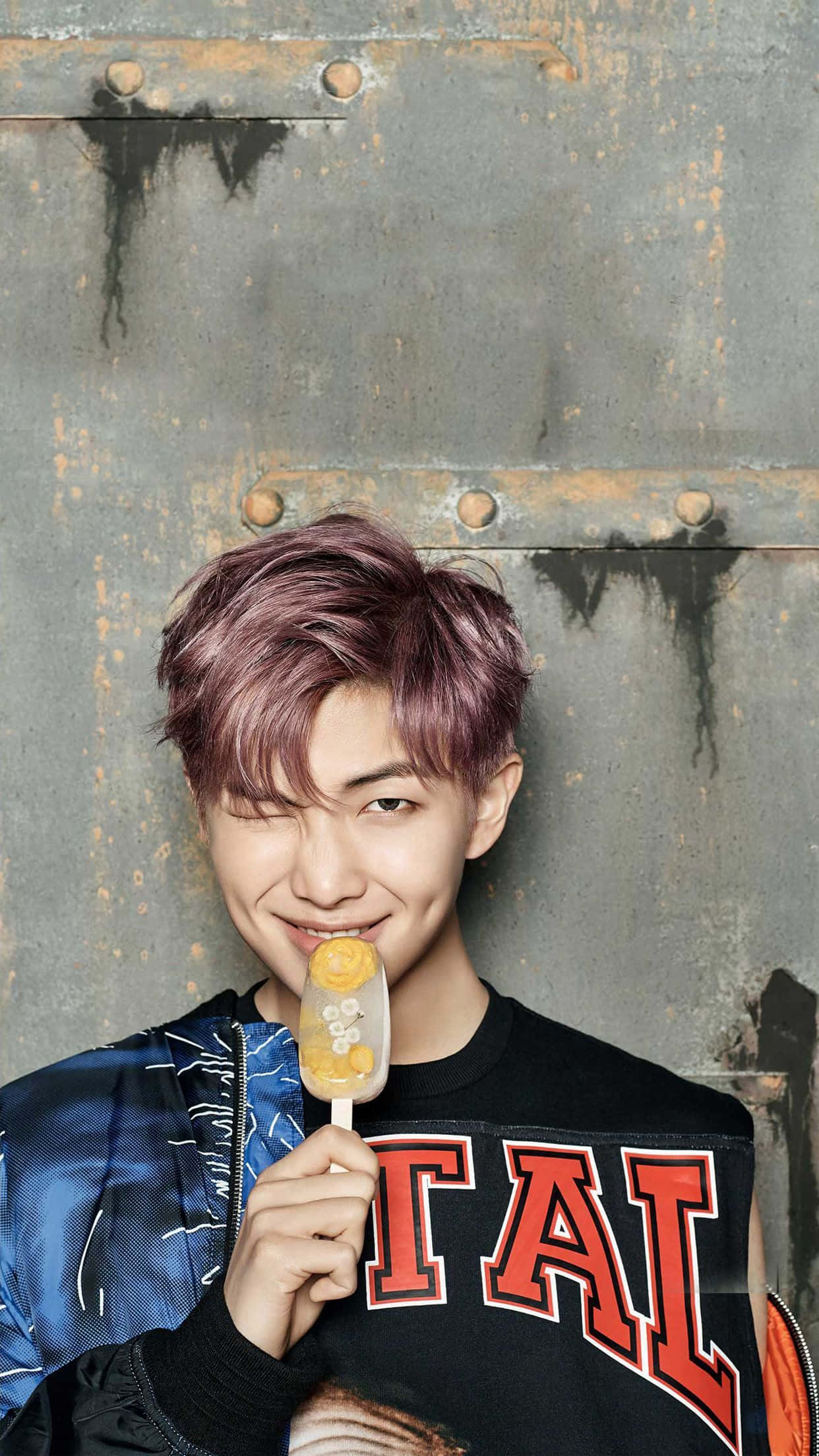Bts Rap Monster 桌布 壁紙 — 一位紫髮年輕男子拿著柑橘冰棒靠在生鏽的金屬門上，眨著眼。