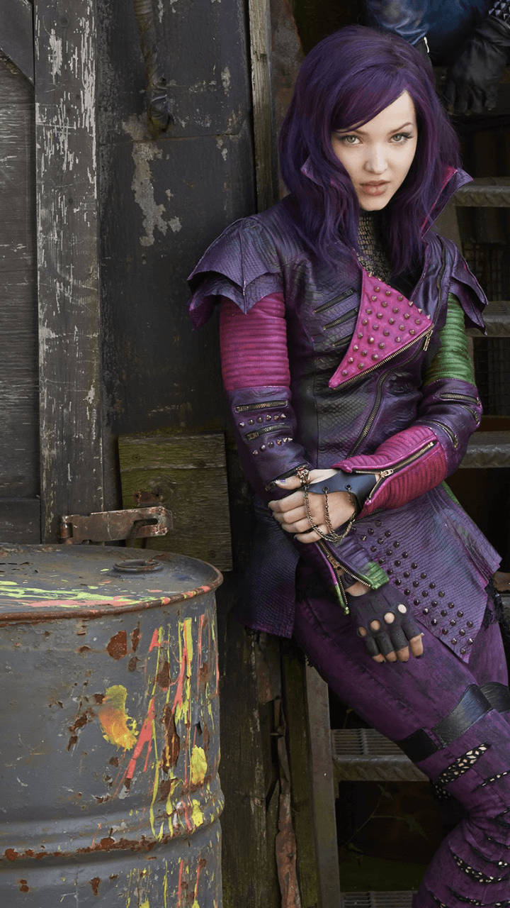 Descendants 桌布 壁紙 — 一位紫髮的兇猛女性穿著鉚釘皮革服裝，靠著風化的木頭，旁邊有一個濺滿油漆的桶。