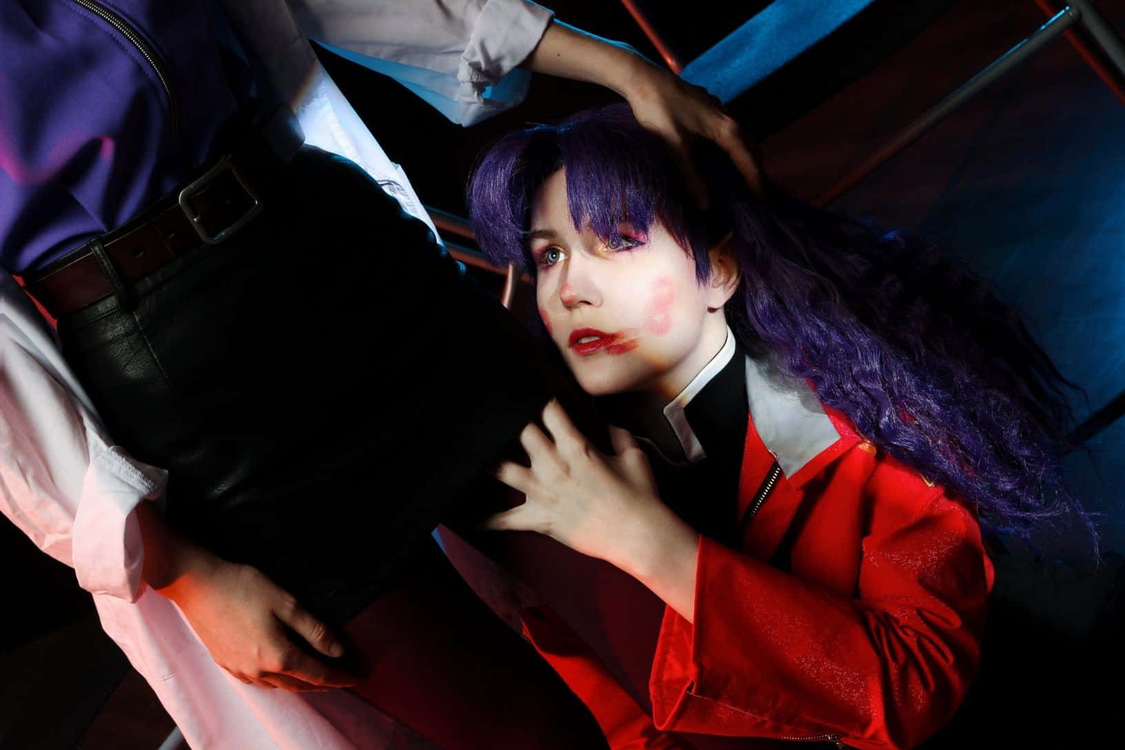 Ritsuko Akagi 桌布 壁紙 — 一位紫髮紅夾克的cosplayer在霓虹燈下戲劇性地躺著，另一個人俯身靠近他們。