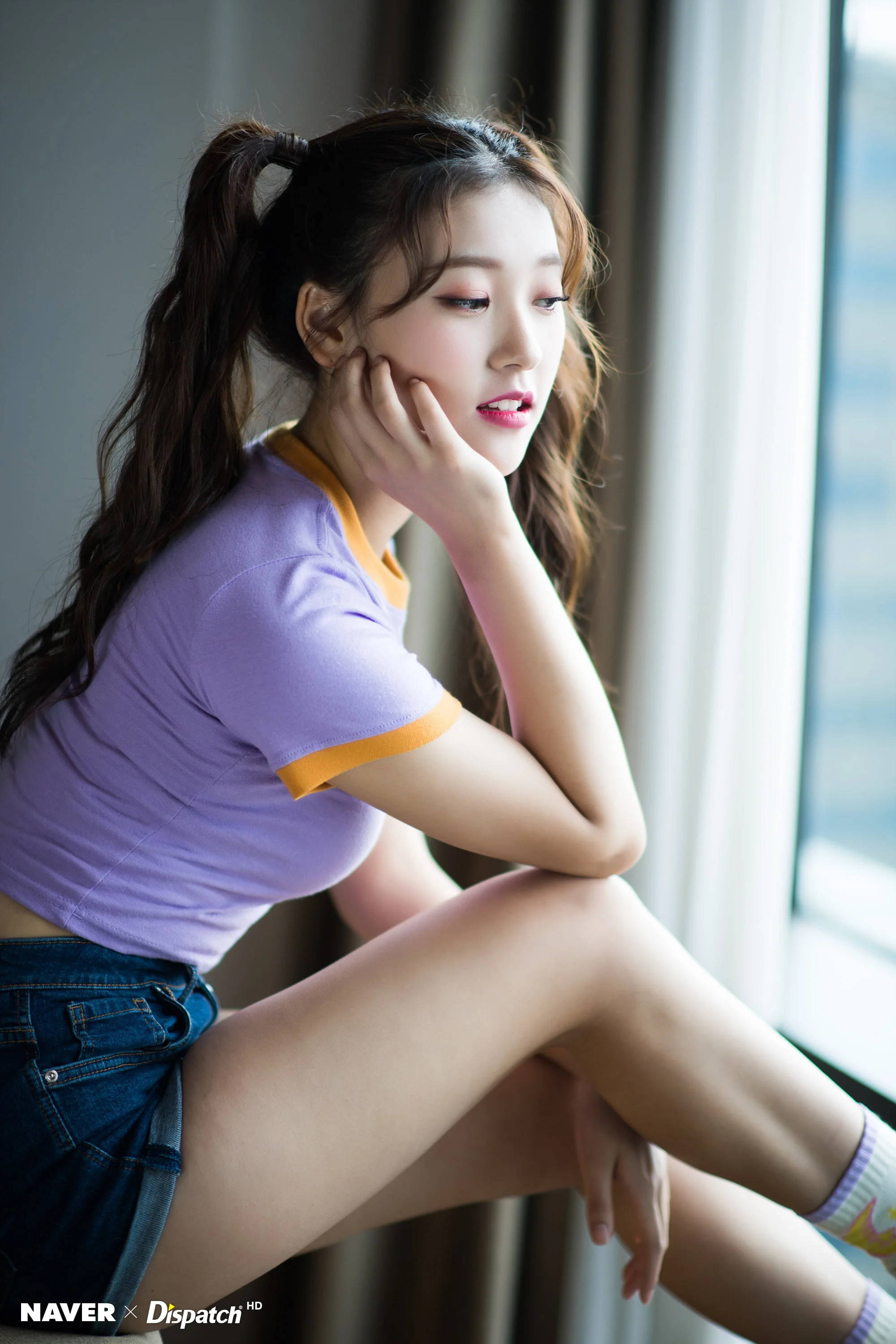 美女 桌布 壁紙 — 一位紮辮子的年輕女性穿著紫色襯衫和牛仔短褲坐在窗邊，若有所思地望著外面。
