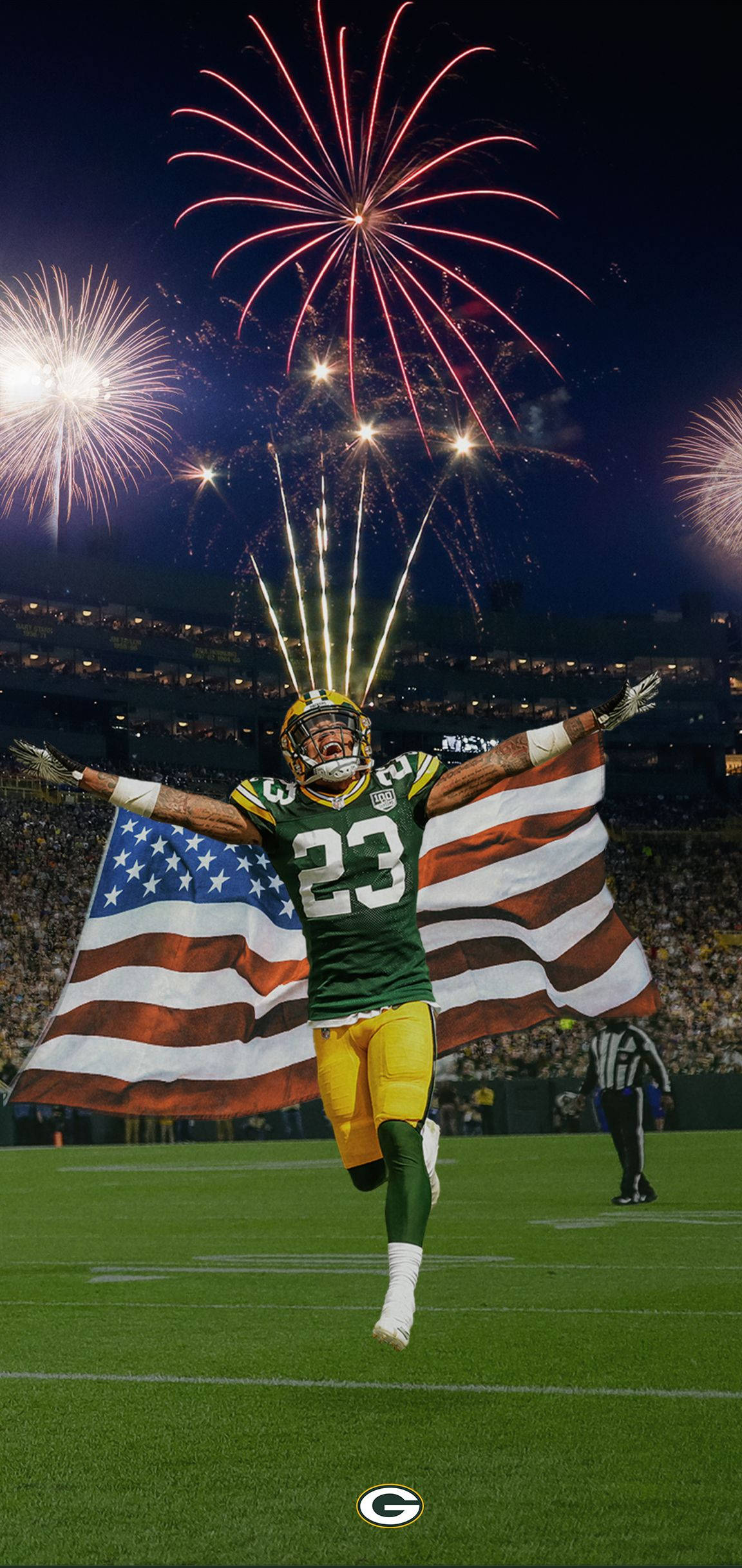 Packers 桌布 壁紙 — 一位綠灣包裝工的美式足球員身穿綠色和金色的23號球衣，在球場上歡樂跳躍，手持美國國旗，夜晚體育場上空煙火綻放。