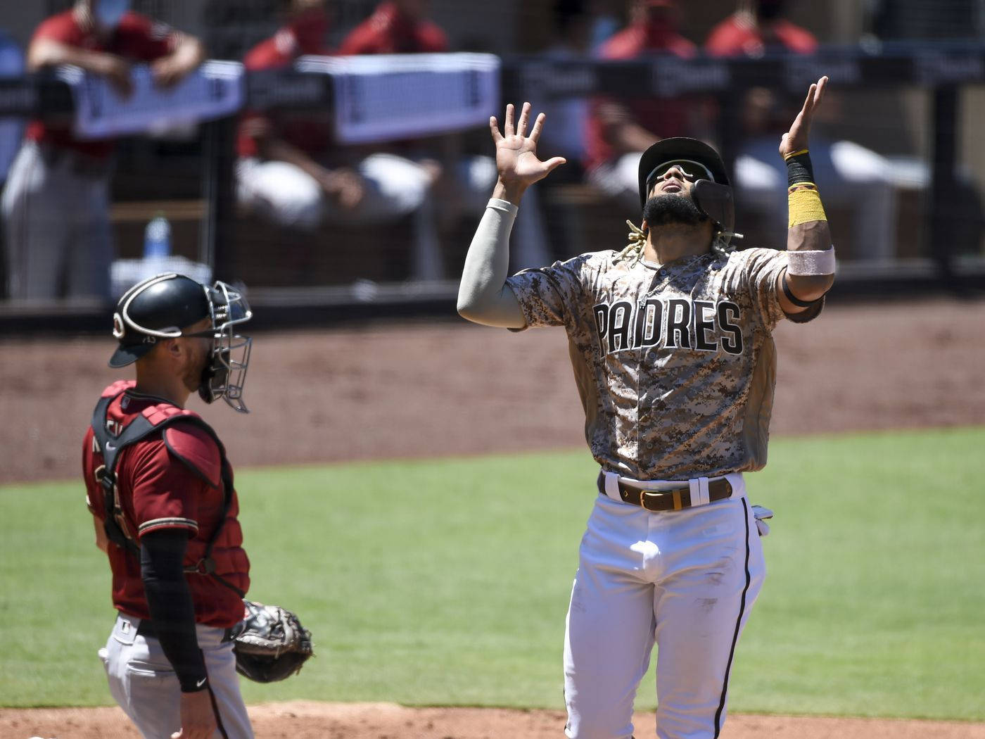 Tatis 桌布 壁紙 — 一位聖地牙哥教士隊的棒球選手在陽光明媚的比賽中高舉雙臂慶祝，捕手在附近觀看。