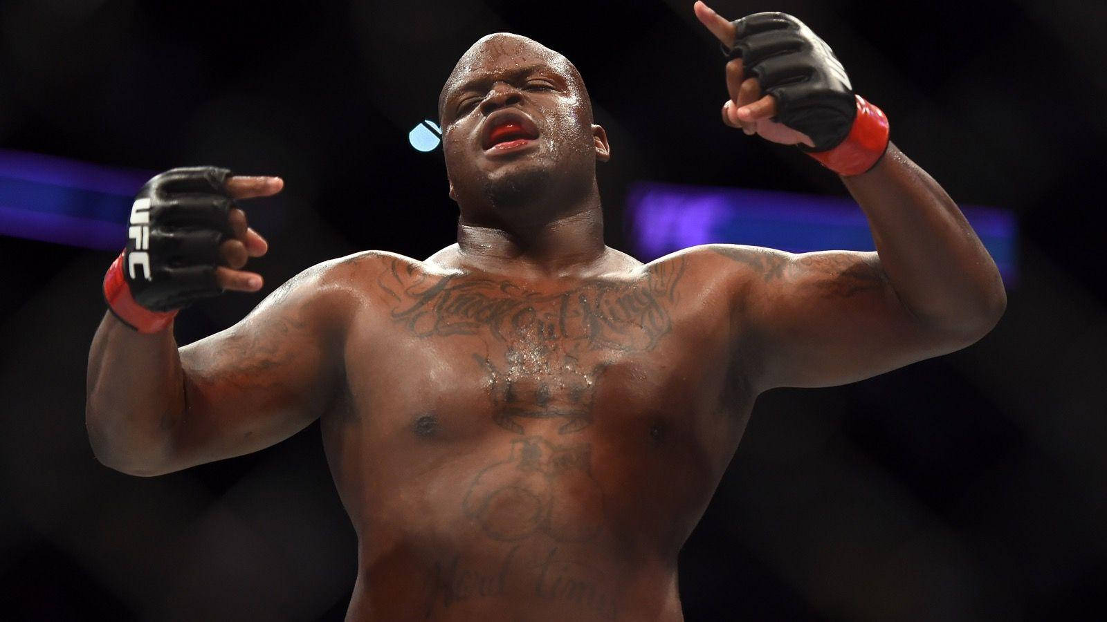 UFC 桌布 壁紙 — 一位肌肉發達、帶有刺青的拳手戴著UFC手套在八角籠中勝利慶祝。