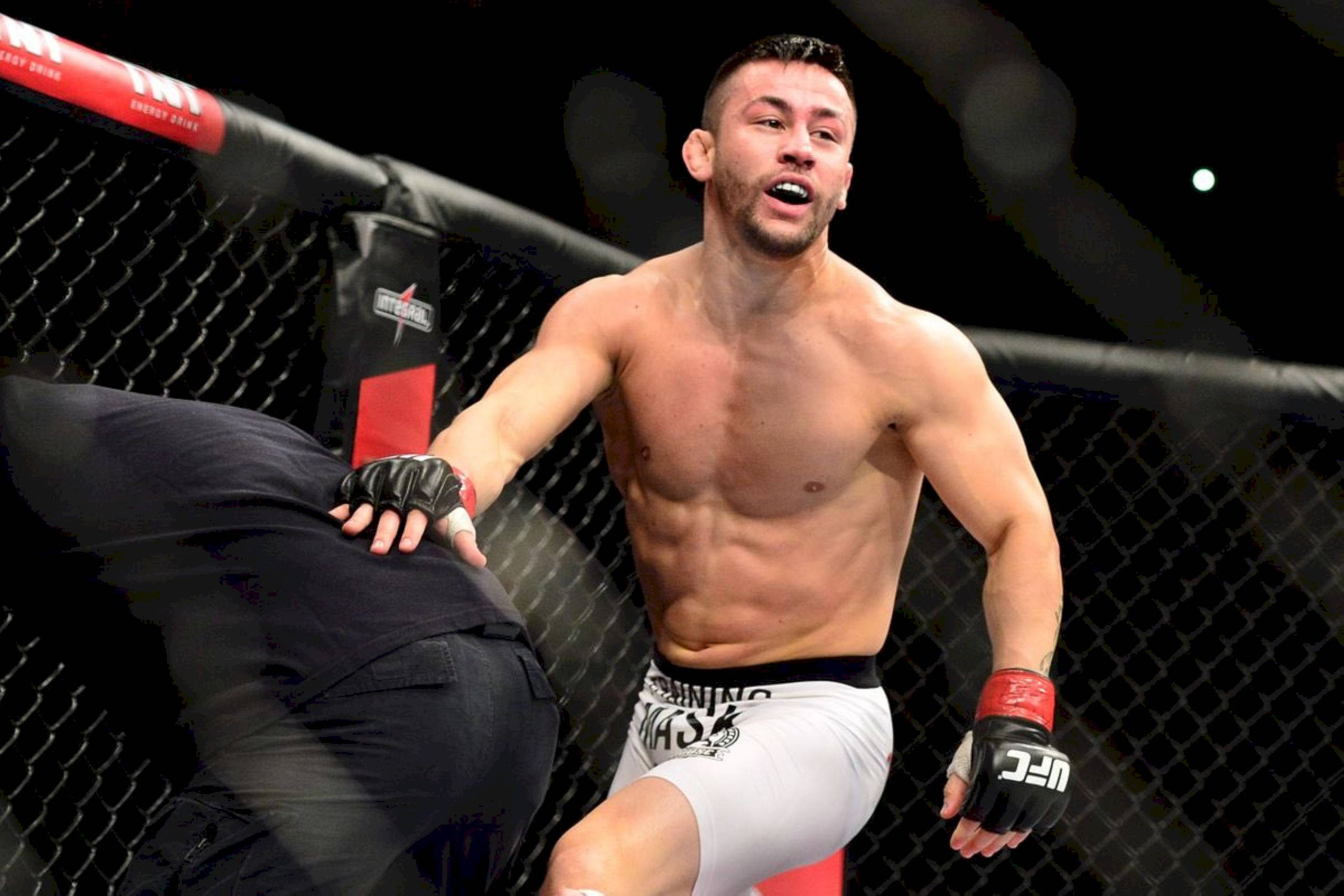 Champion 桌布 壁紙 — 一位肌肉發達的MMA拳手在昏暗的八角籠內，於一場高風險比賽中施展強力踢擊。
