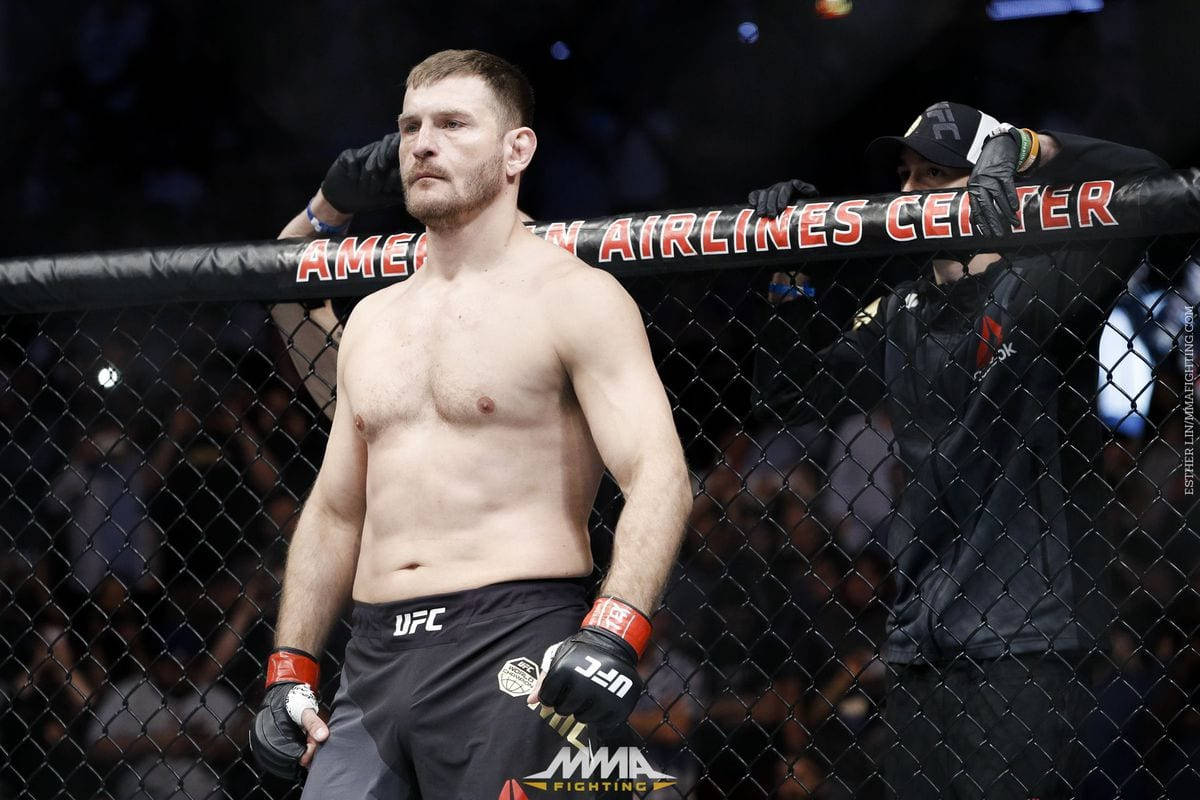 UFC 桌布 壁紙 — 一位肌肉發達的MMA拳手站在美國航空中心的八角籠內，表情專注。