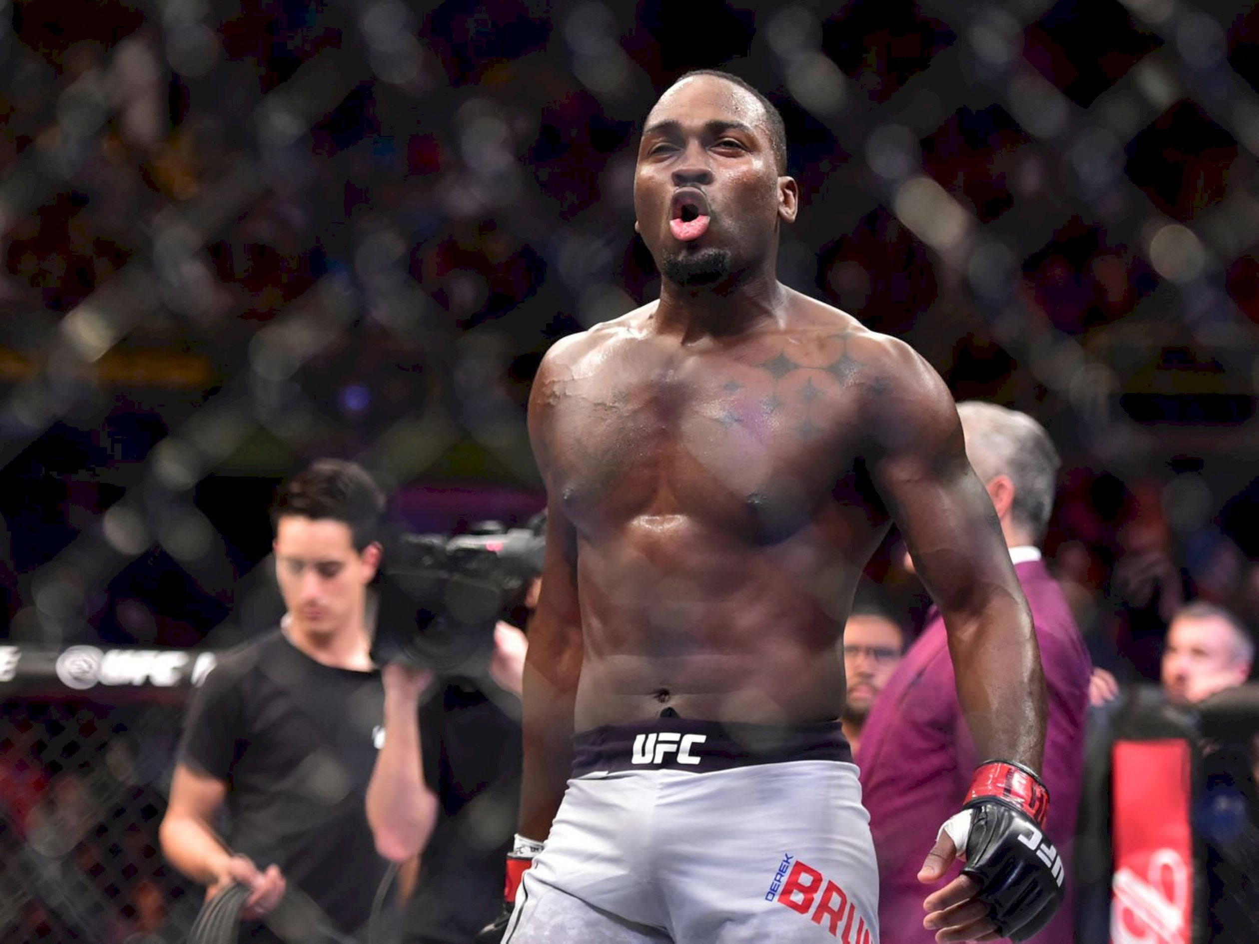 Champion 桌布 壁紙 — 一位肌肉發達的UFC拳手在八角籠中伸出舌頭，表情激烈地慶祝勝利。