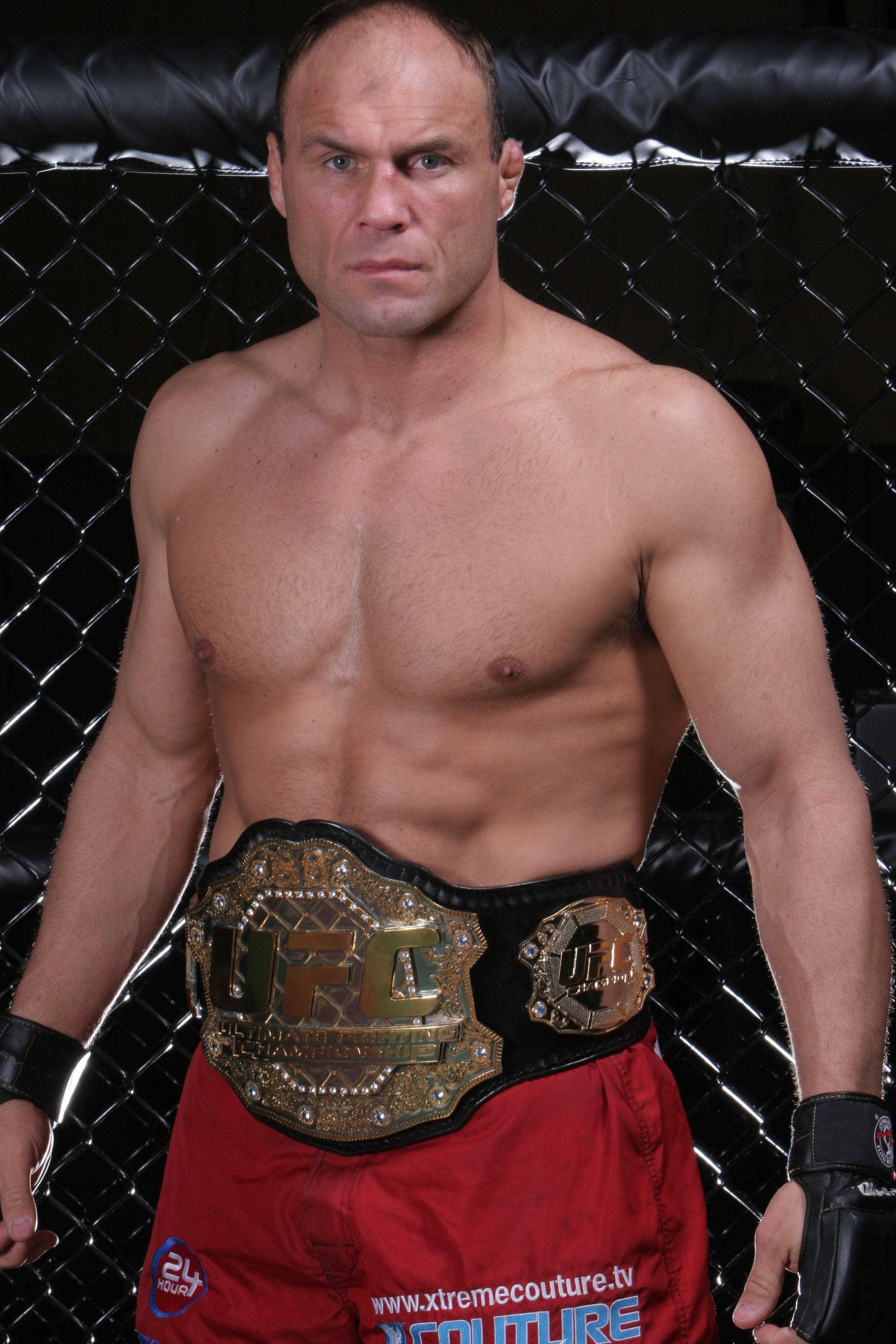 Champion 桌布 壁紙 — 一位肌肉發達的UFC拳手在八角籠內佩戴冠軍腰帶，眼神銳利。
