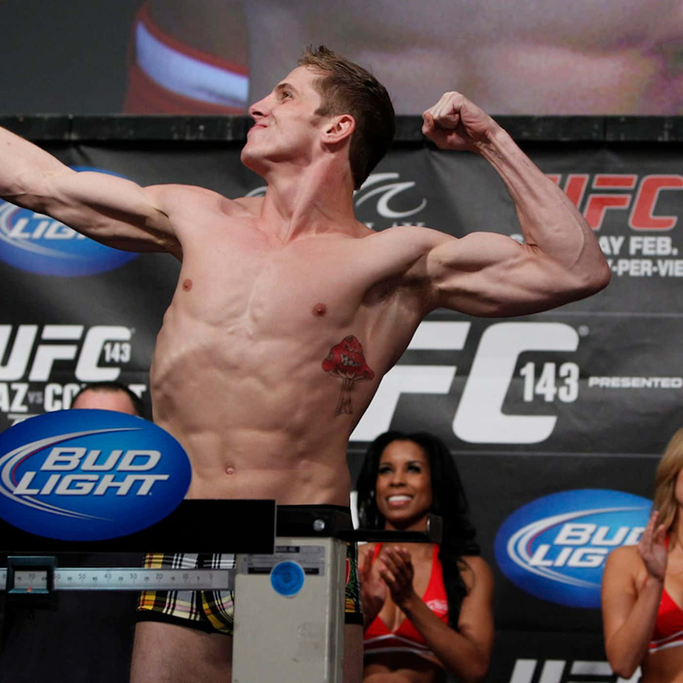 Athlete 桌布 壁紙 — 一位肌肉發達的UFC拳手在稱重活動中勝利地展示肌肉，身後有粉絲歡呼。