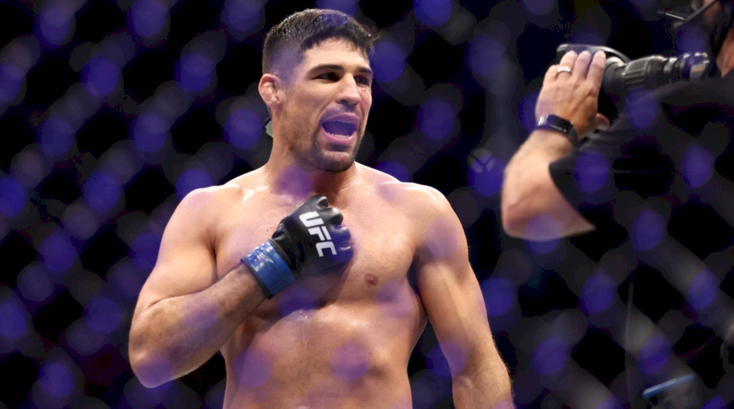 UFC 桌布 壁紙 — 一位肌肉發達的UFC拳手在紫色燈光下，張開嘴巴，手放在胸前，在八角籠中慶祝勝利。