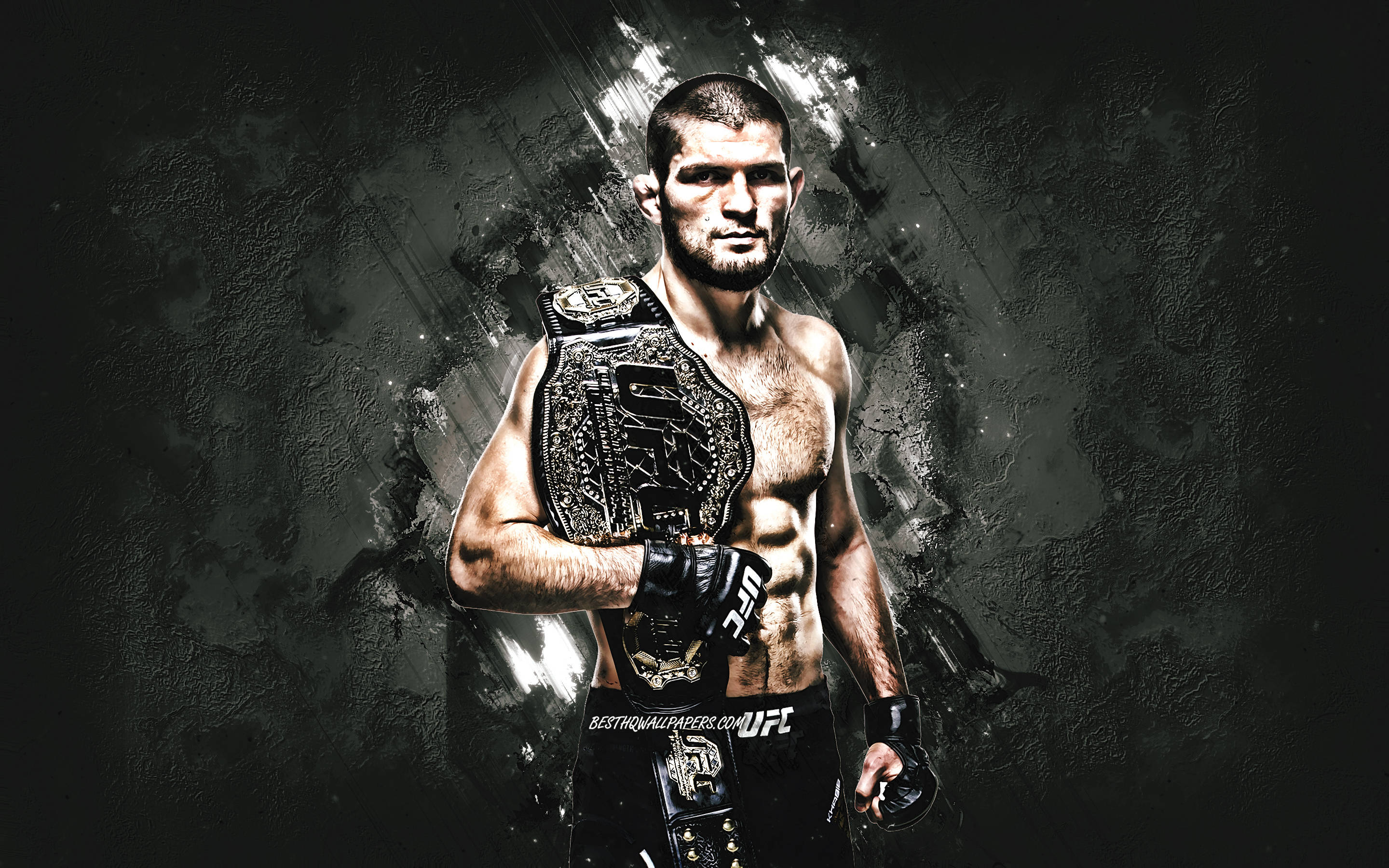 UFC 桌布 壁紙 — 一位肌肉發達的UFC拳手帶著冠軍腰帶，在戲劇性燈光下自信地站在深色紋理背景前。