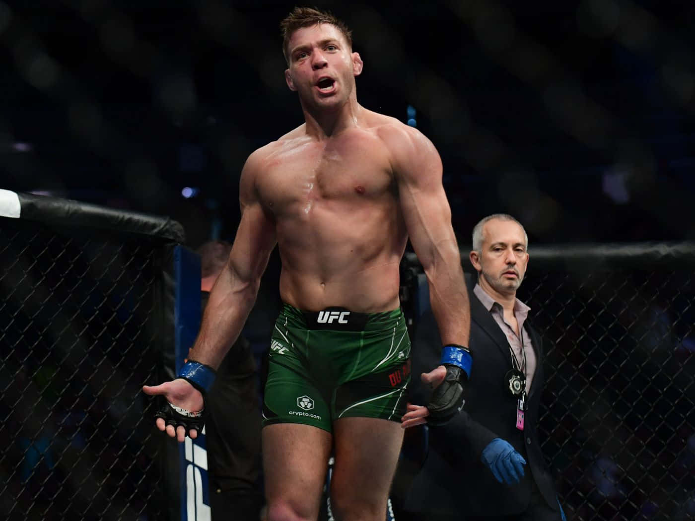 桌布 壁紙 — 一位肌肉發達的UFC拳手穿著綠色短褲，在八角籠內發出勝利的咆哮慶祝勝利。
