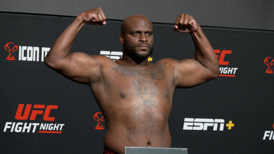 MMA 桌布 壁紙 — 一位肌肉發達的光頭拳手在UFC稱重活動中彎曲手臂，背景有ESPN品牌標誌。