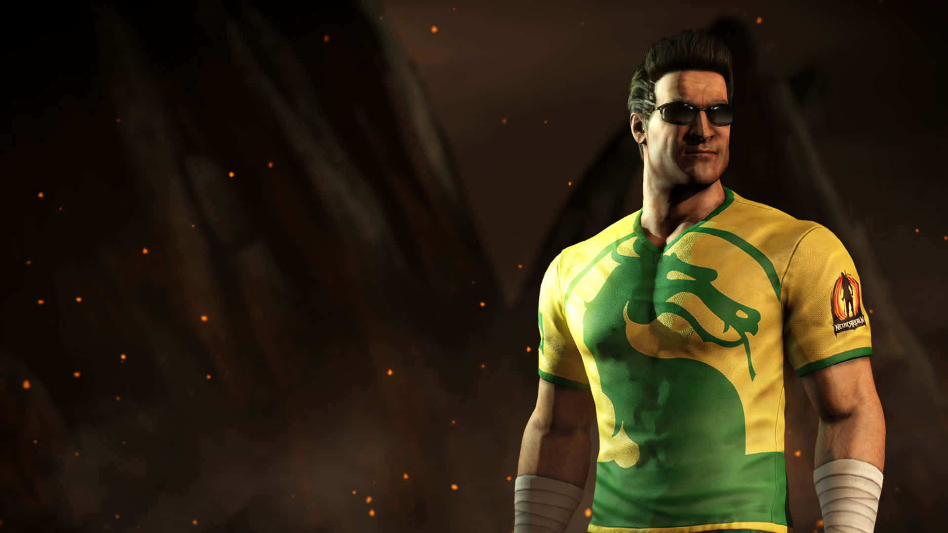 Johnny Cage 桌布 壁紙 — 一位肌肉發達的戰士穿著黃綠龍紋襯衫，自信地站在煙霧繚繞的火熱背景前。