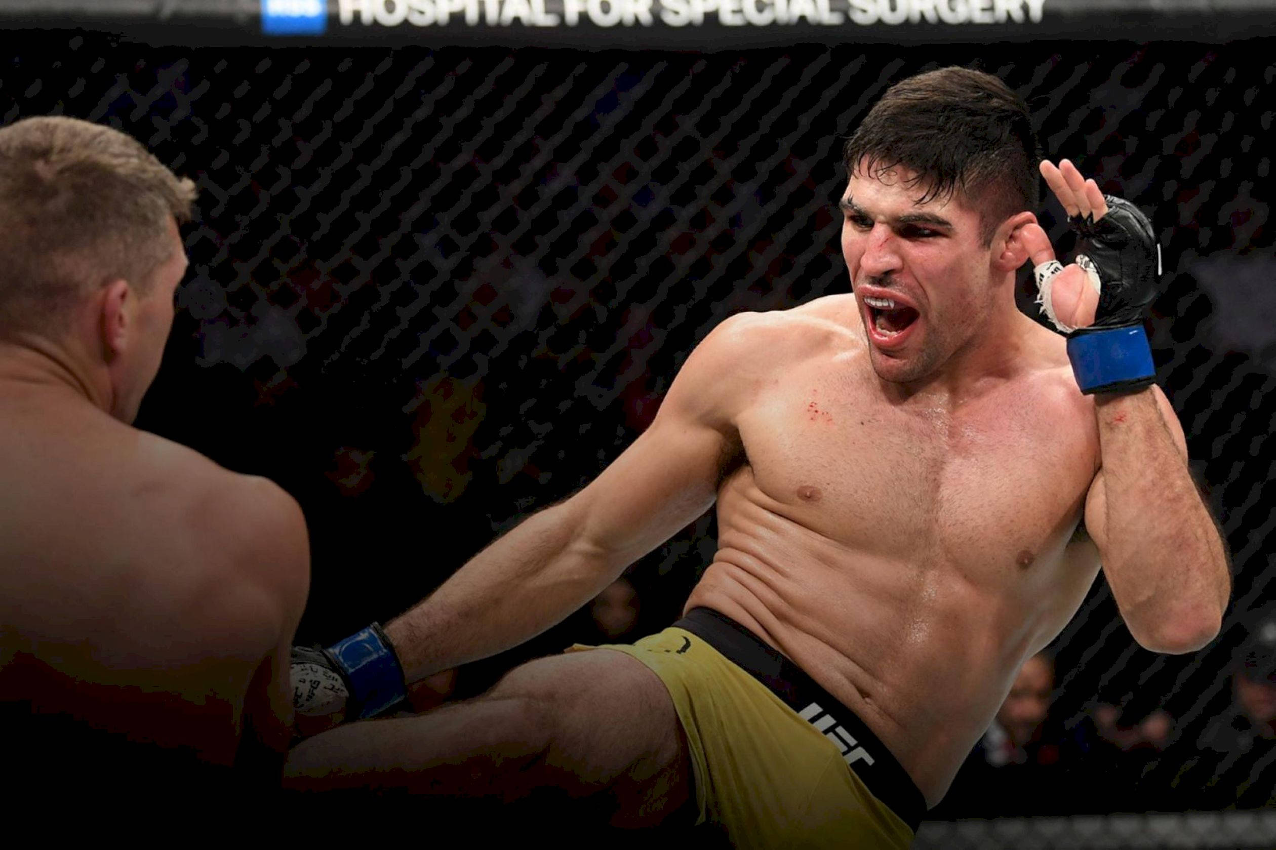 MMA 桌布 壁紙 — 一位肌肉發達的拳手穿著黃色短褲，在UFC八角籠內以強烈的專注力和侵略性踢出強力一腳。