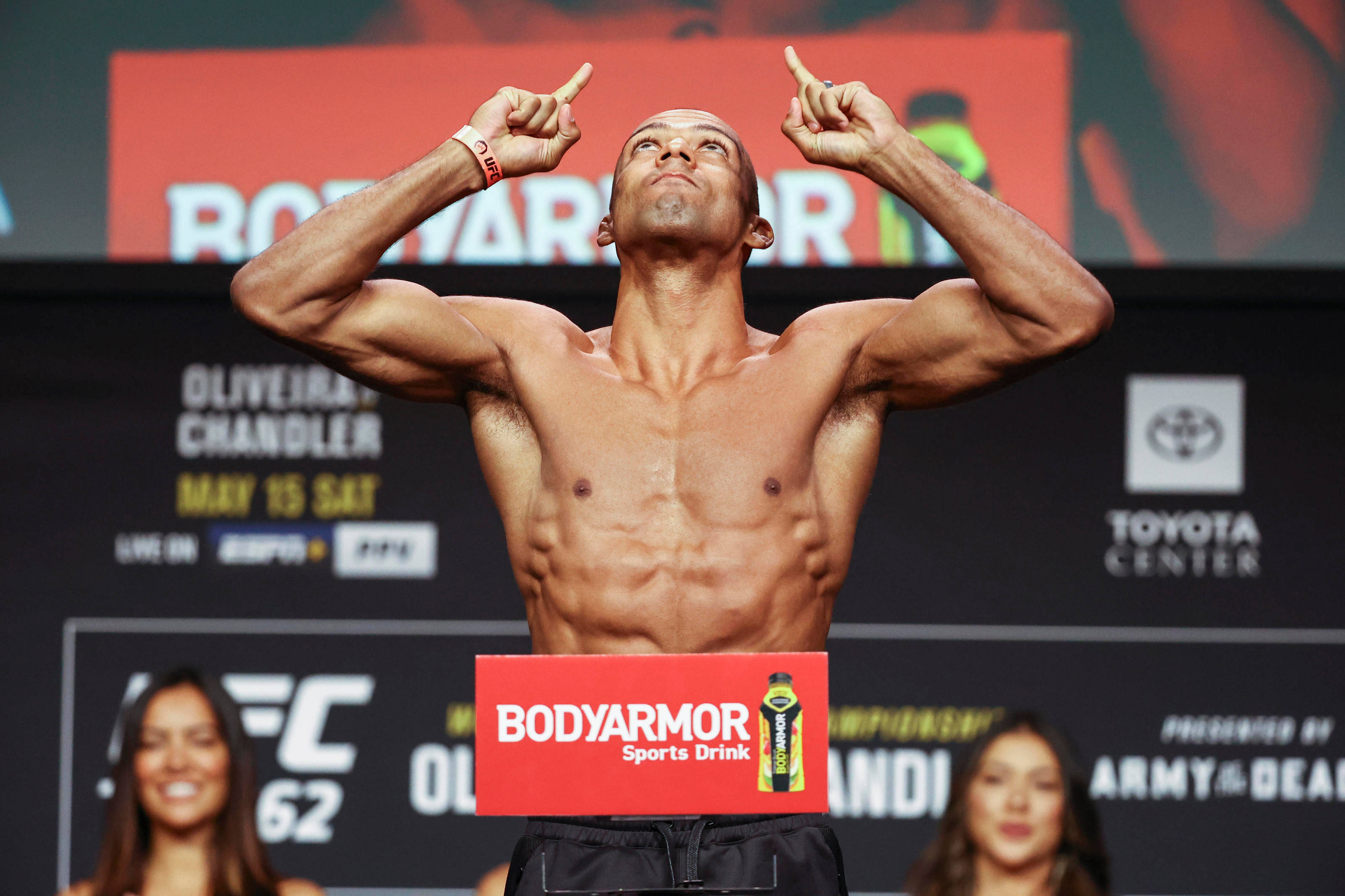 MMA 桌布 壁紙 — 一位肌肉發達的拳手赤裸上身站在UFC稱重儀式的體重磅上，雙食指指向上方。