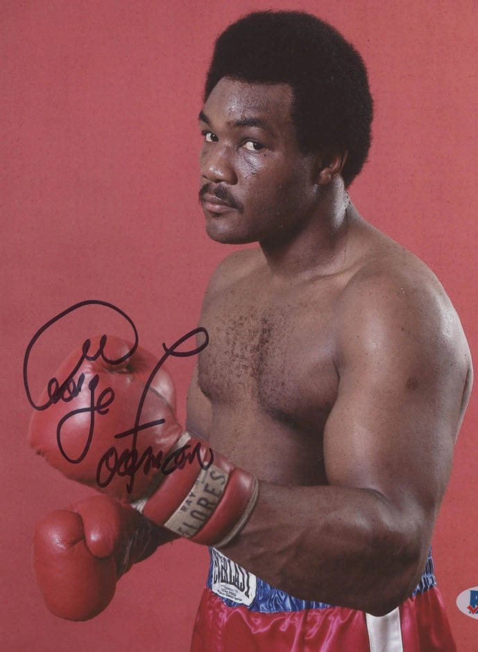 Boxing 桌布 壁紙 — 一位肌肉發達的拳擊手，身穿紅色手套和短褲，在純紅色背景前自信地擺姿勢，簽名清晰可見。