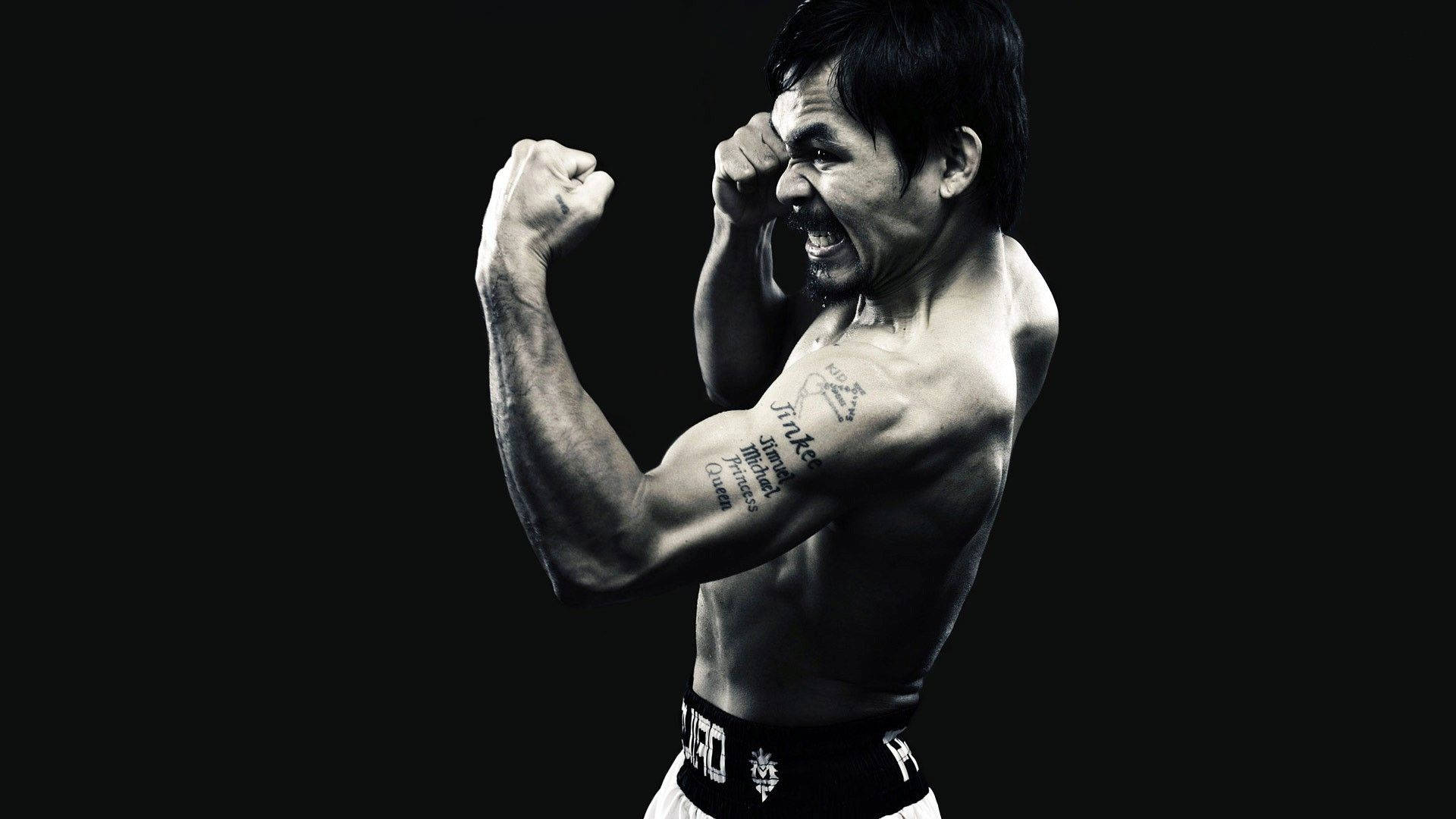 Boxing 桌布 壁紙 — 一位肌肉發達的拳擊手在黑色背景下握緊拳頭，發出勝利的咆哮。