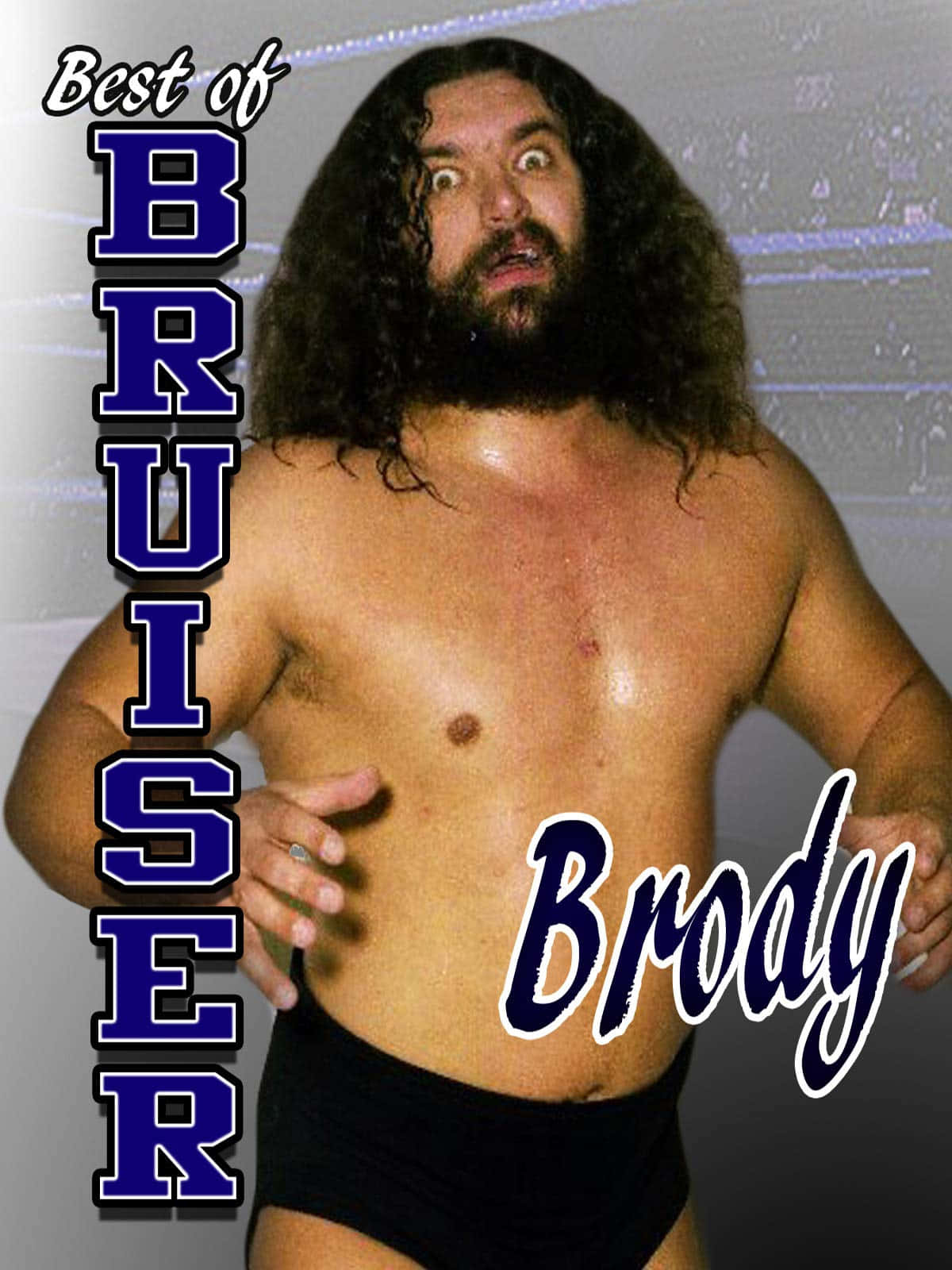 WWE 桌布 壁紙 — 一位肌肉發達的摔角手，留著長捲髮和鬍鬚，穿著黑色緊身短褲，在模糊的競技場背景下凝視著。