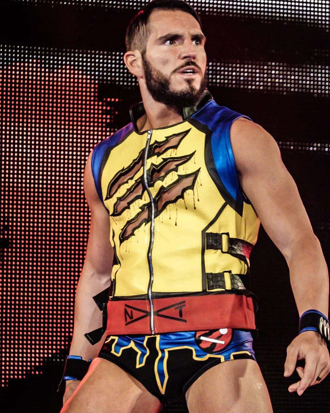 WWE 桌布 壁紙 — 一位肌肉發達的摔角手，身穿鮮豔的黃、藍、紅色服裝，在像素化背景前被舞台燈光強烈照射。