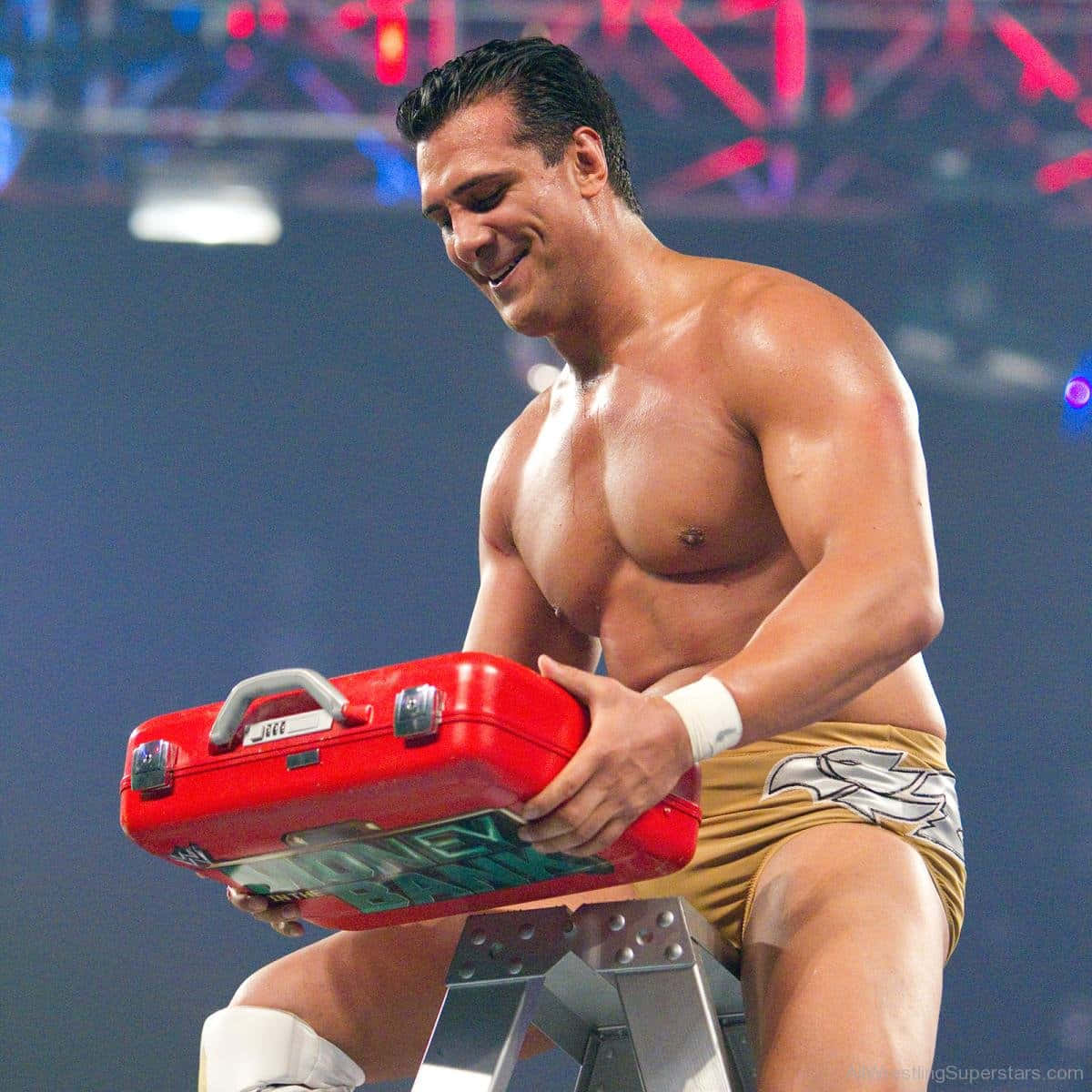 WWE 桌布 壁紙 — 一位肌肉發達的摔角手在競技場燈光下微笑，手持紅色工具箱放在金屬凳上。