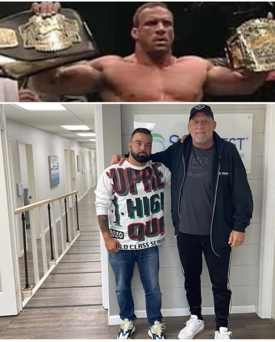 WWE 桌布 壁紙 — 一位肌肉發達的摔角手將兩條冠軍腰帶高舉過頭，兩名男子在現代走廊中一起擺姿勢。