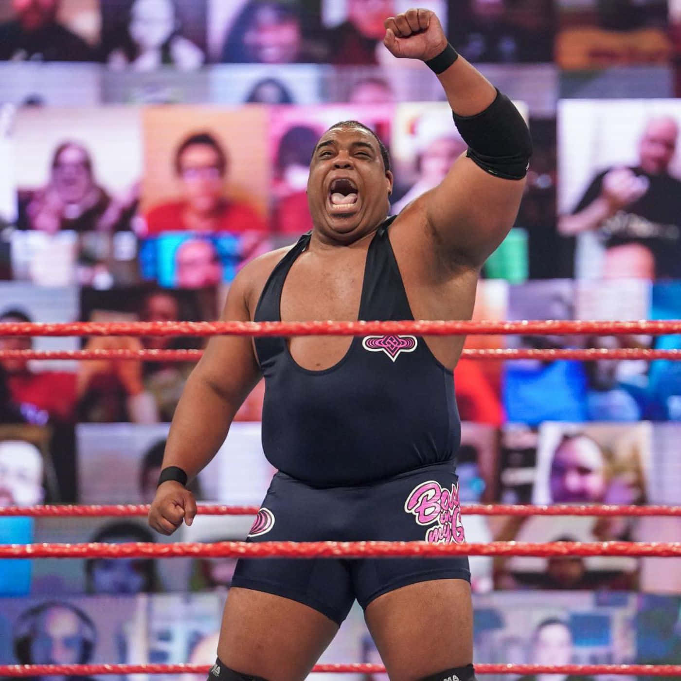 WWE 桌布 壁紙 — 一位肌肉發達的摔角手穿著黑色緊身衣，在紅色繩索的擂台上勝利咆哮，而粉絲的臉孔在數位背景上發光。
