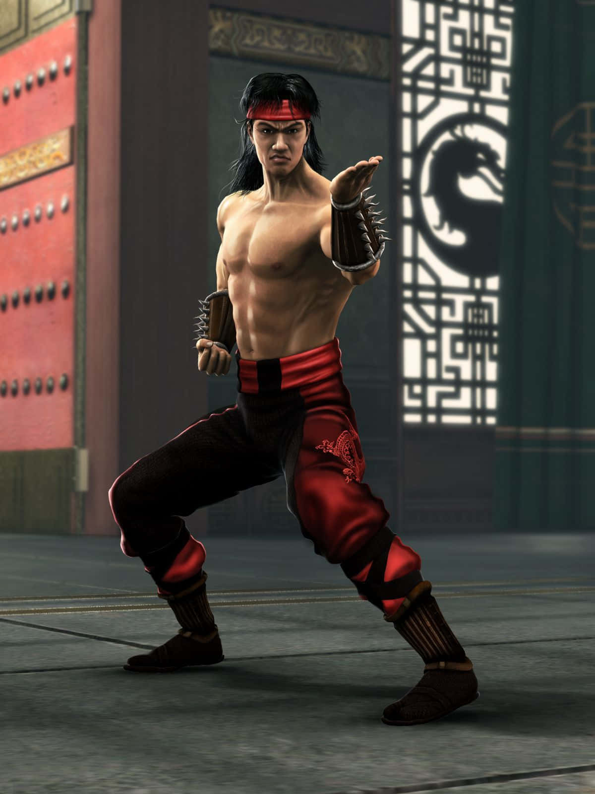 Mortal Kombat Liu Kang 桌布 壁紙 — 一位肌肉發達的武術家身穿紅黑道服，在華麗的亞洲風格門前擺出戰鬥姿勢。