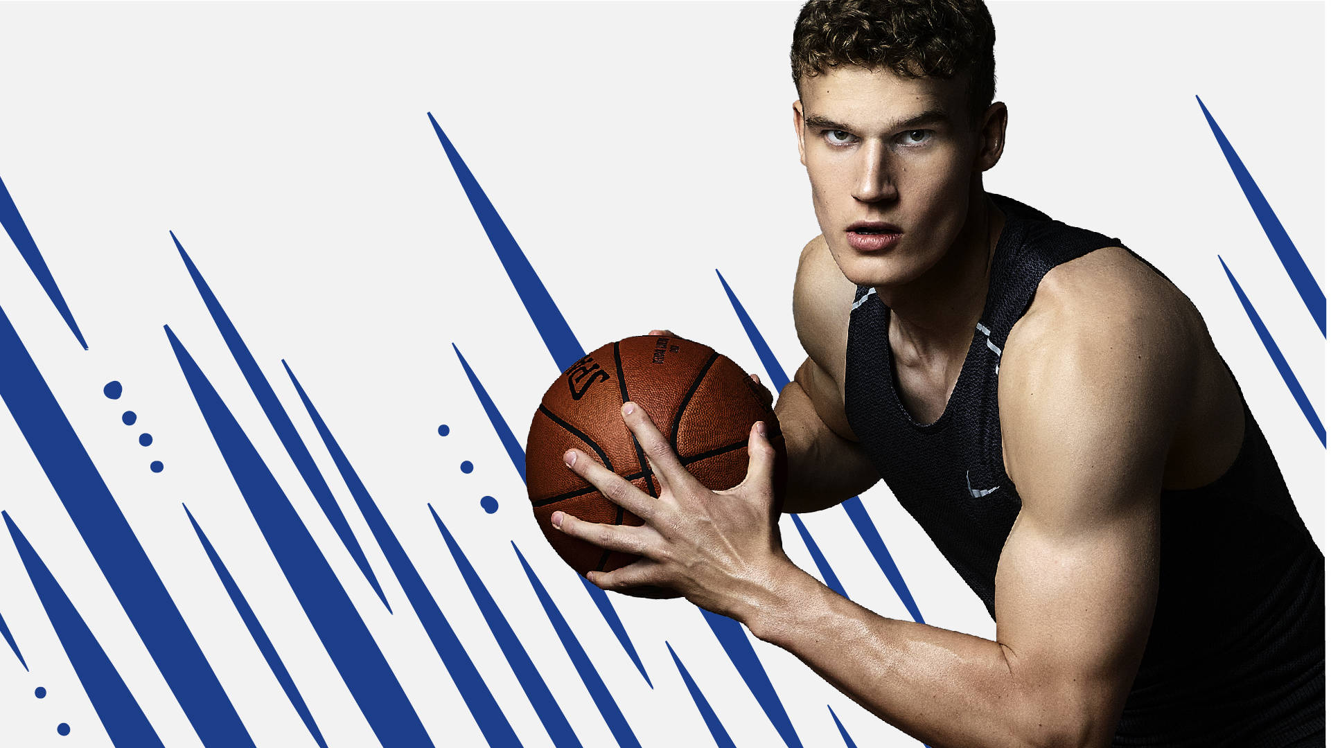 NBA 桌布 壁紙 — 一位肌肉發達的籃球運動員身穿黑色背心，在動態的藍白圖形背景前，專注地抓住籃球。
