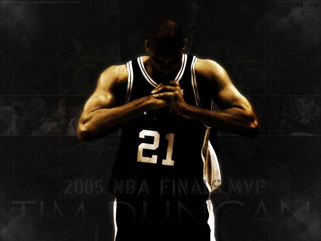 Tim Duncan 桌布 壁紙 — 一位肌肉發達的籃球運動員身穿黑色21號球衣，在深色紋理背景前雙手合十，展現安靜的專注時刻。