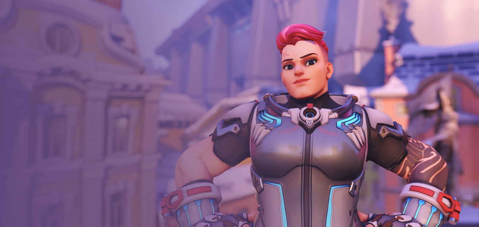 Overwatch Zarya 桌布 壁紙 — 一位自信的女性英雄穿著未來裝甲，雙手叉腰站在雪景歐洲風格的城市景觀前。