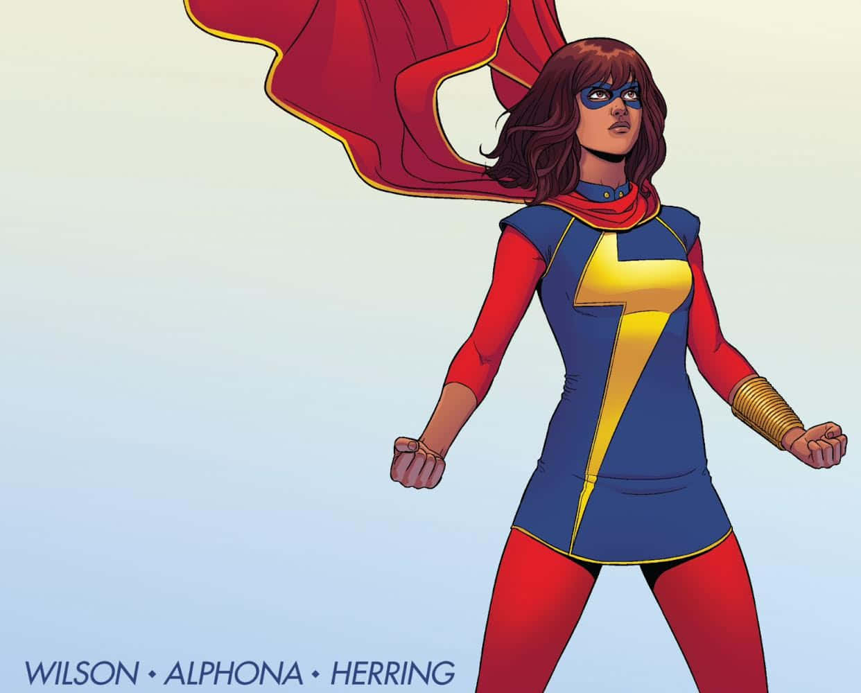 Best Captain Marvel 桌布 壁紙 — 一位自信的女性超級英雄，身穿藍、紅、黃色服裝，披著飄逸的斗篷，站在柔和的漸變背景前。