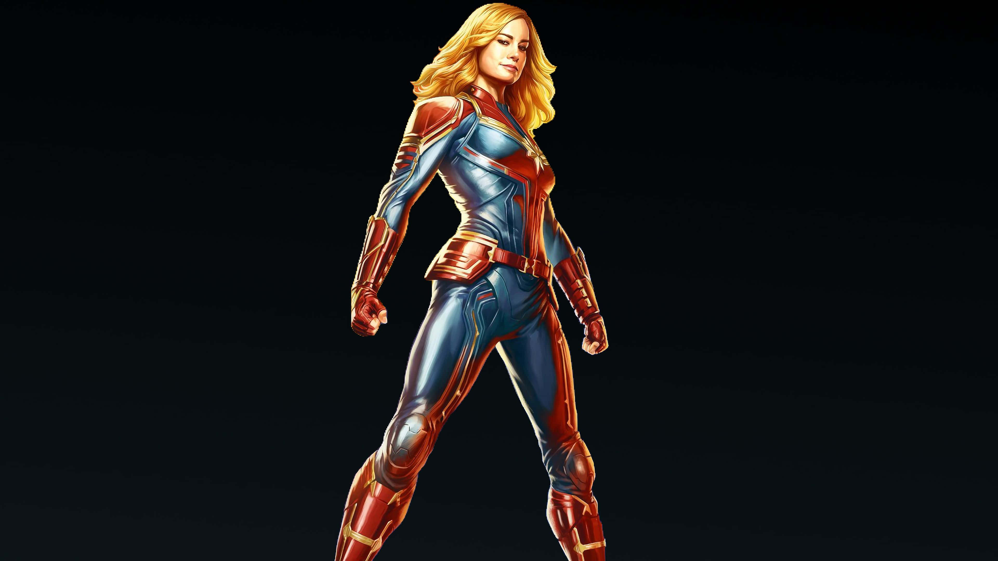 桌布 壁紙 — 一位自信的女超級英雄身穿藍色和紅色套裝，在深色漸變背景前擺好姿勢。