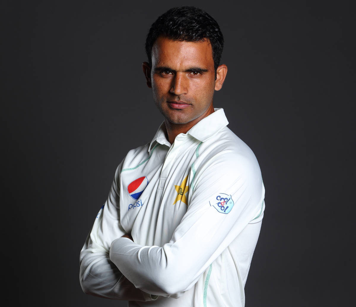 Fakhar Zaman 桌布 壁紙 — 一位自信的板球運動員身穿白色制服，在深色工作室背景下交叉雙臂站立。