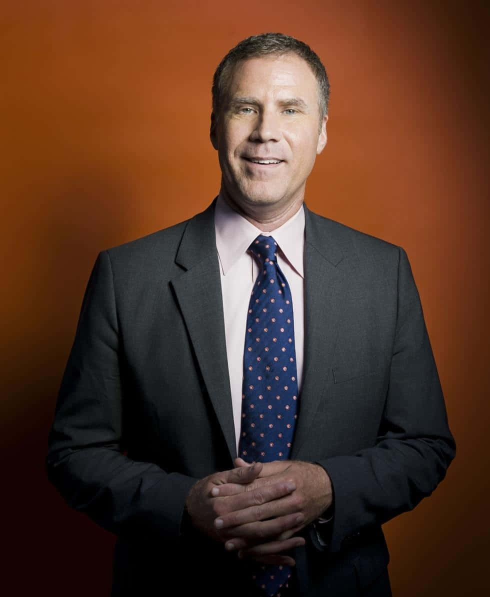 will ferrell 桌布 壁紙 — 一位自信的男子身穿深色西裝配圓點領帶，在豐富的橙色工作室背景下溫暖地微笑。