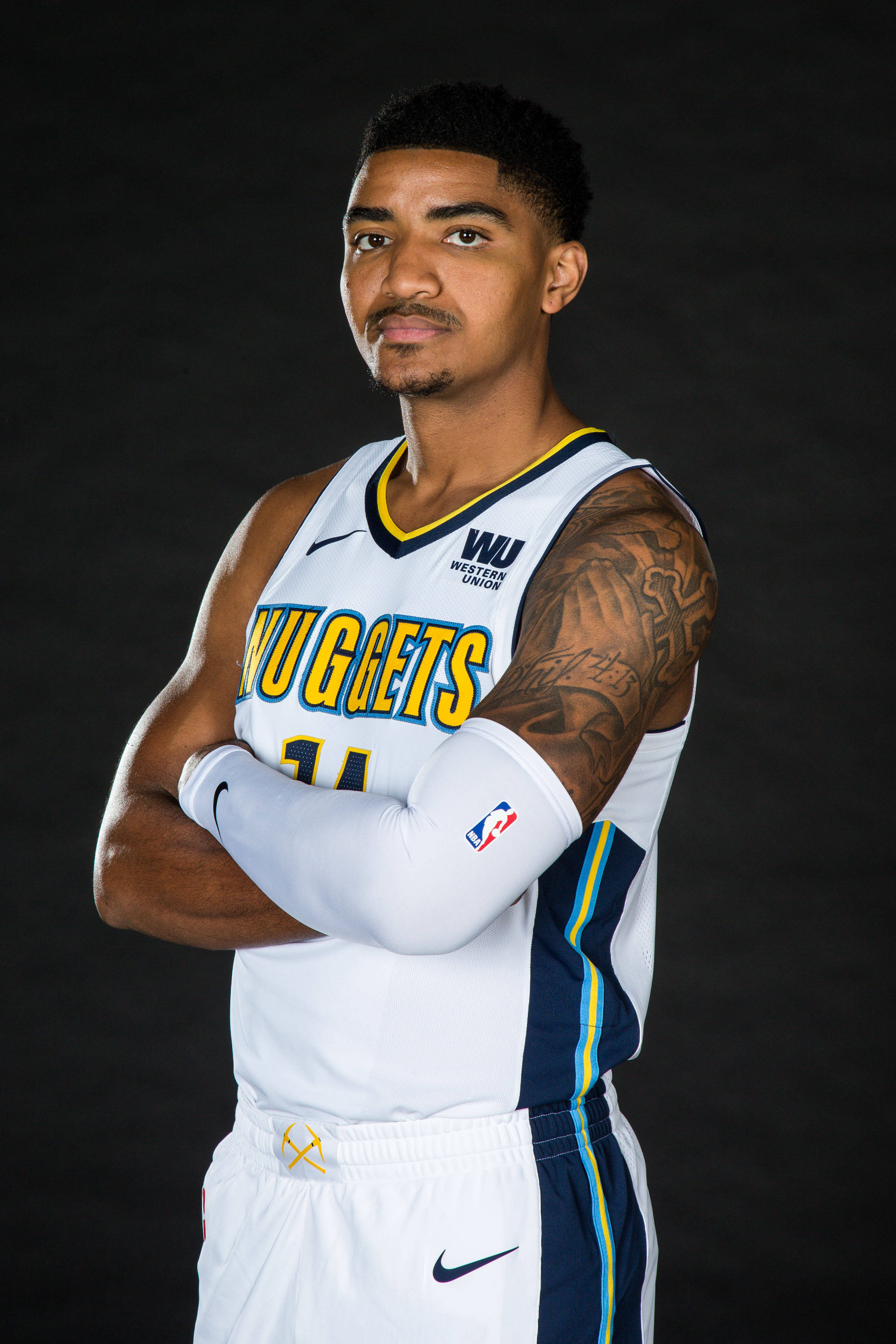 gary harris 桌布 壁紙 — 一位自信的籃球運動員身穿丹佛金塊隊球衣，在深色攝影棚背景前交叉雙臂站立。