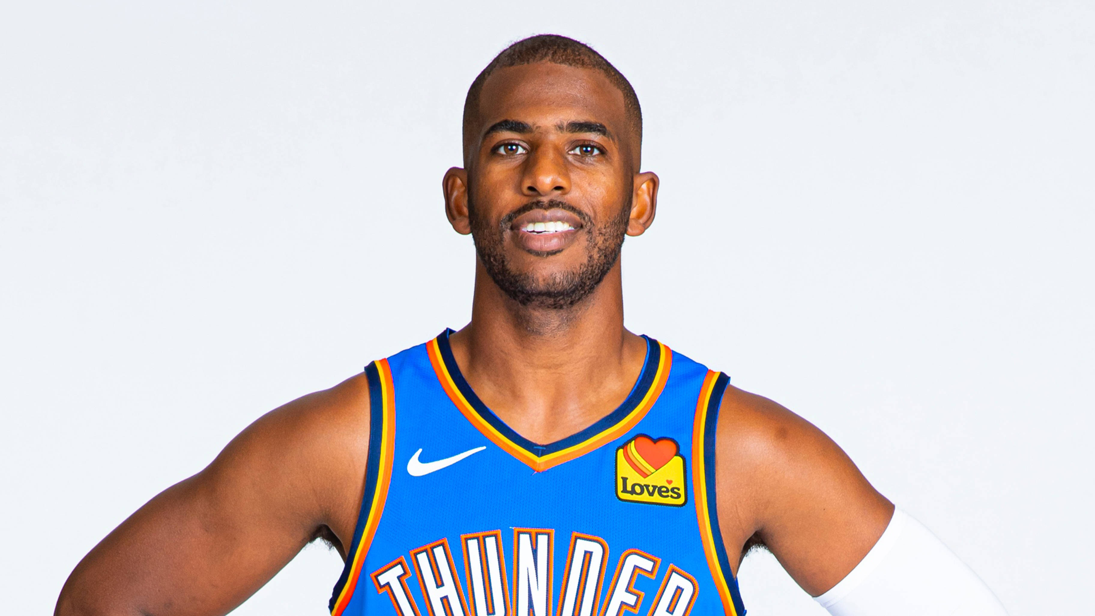 Chris Paul 桌布 壁紙 — 一位自信的籃球運動員身穿藍色奧克拉荷馬城雷霆隊球衣，在純白色背景前擺姿勢。