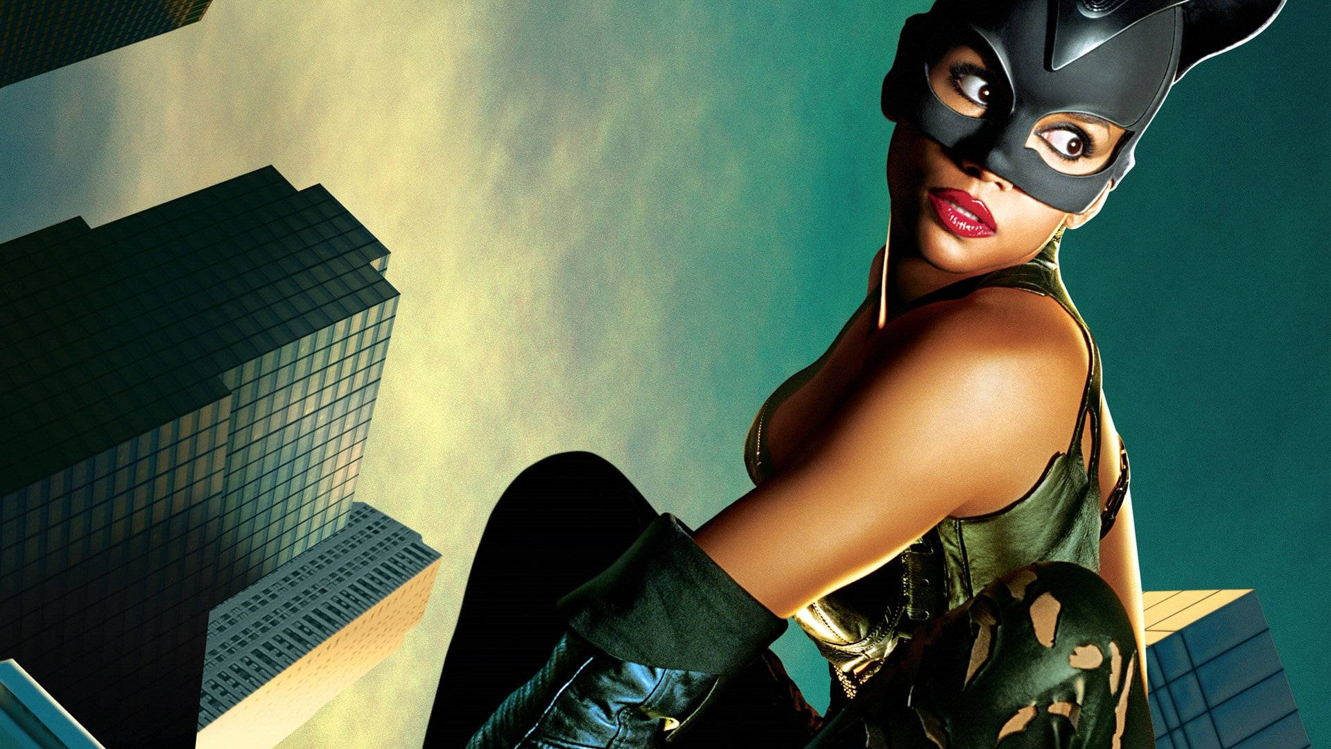 Catwoman 桌布 壁紙 — 一位自信的貓女，戴著黑色面具，身穿綠色服裝，在摩天大樓頂端以藍綠色和金色天空為背景擺姿勢。
